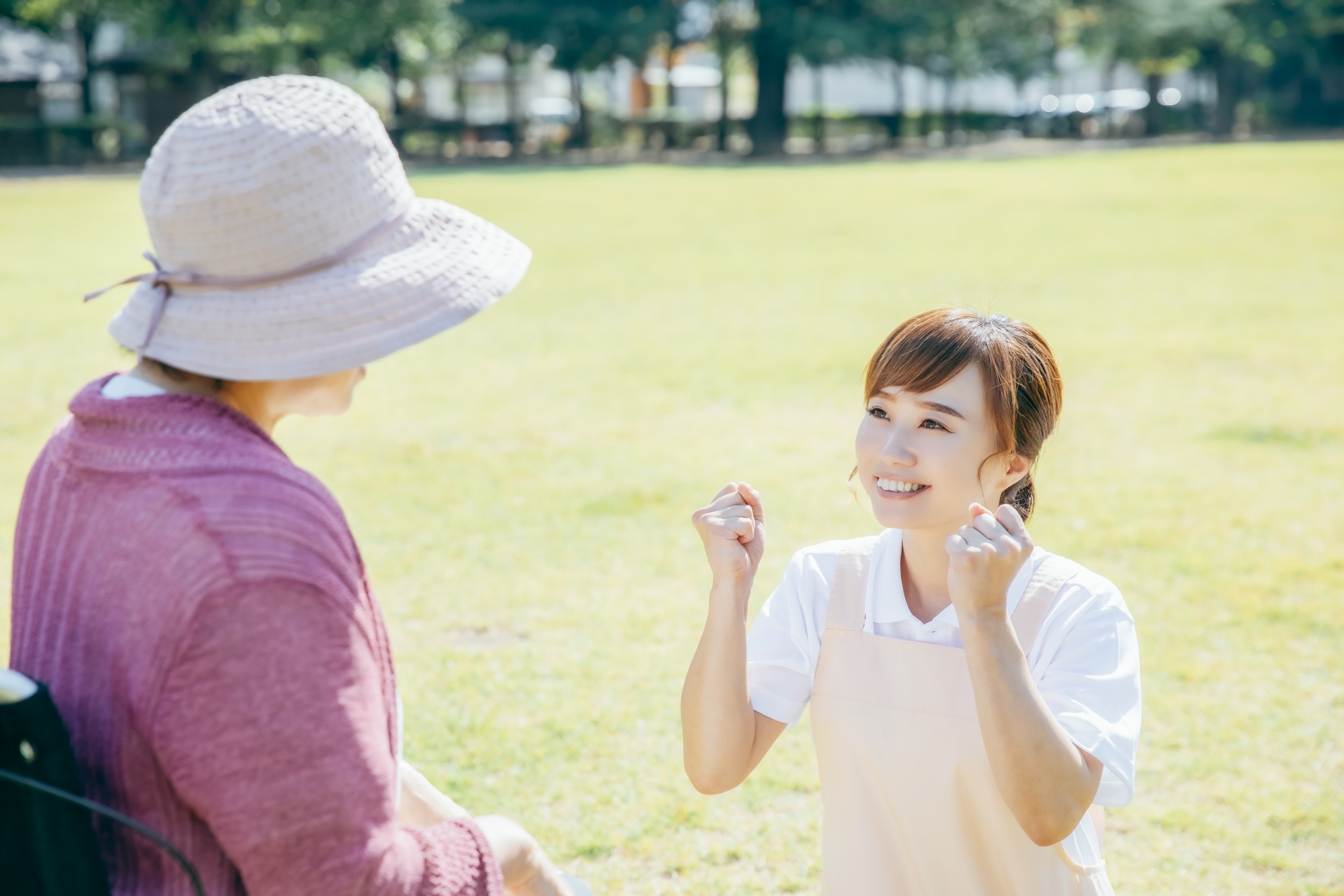 屋外で高齢女性に話しかける介護スタッフ