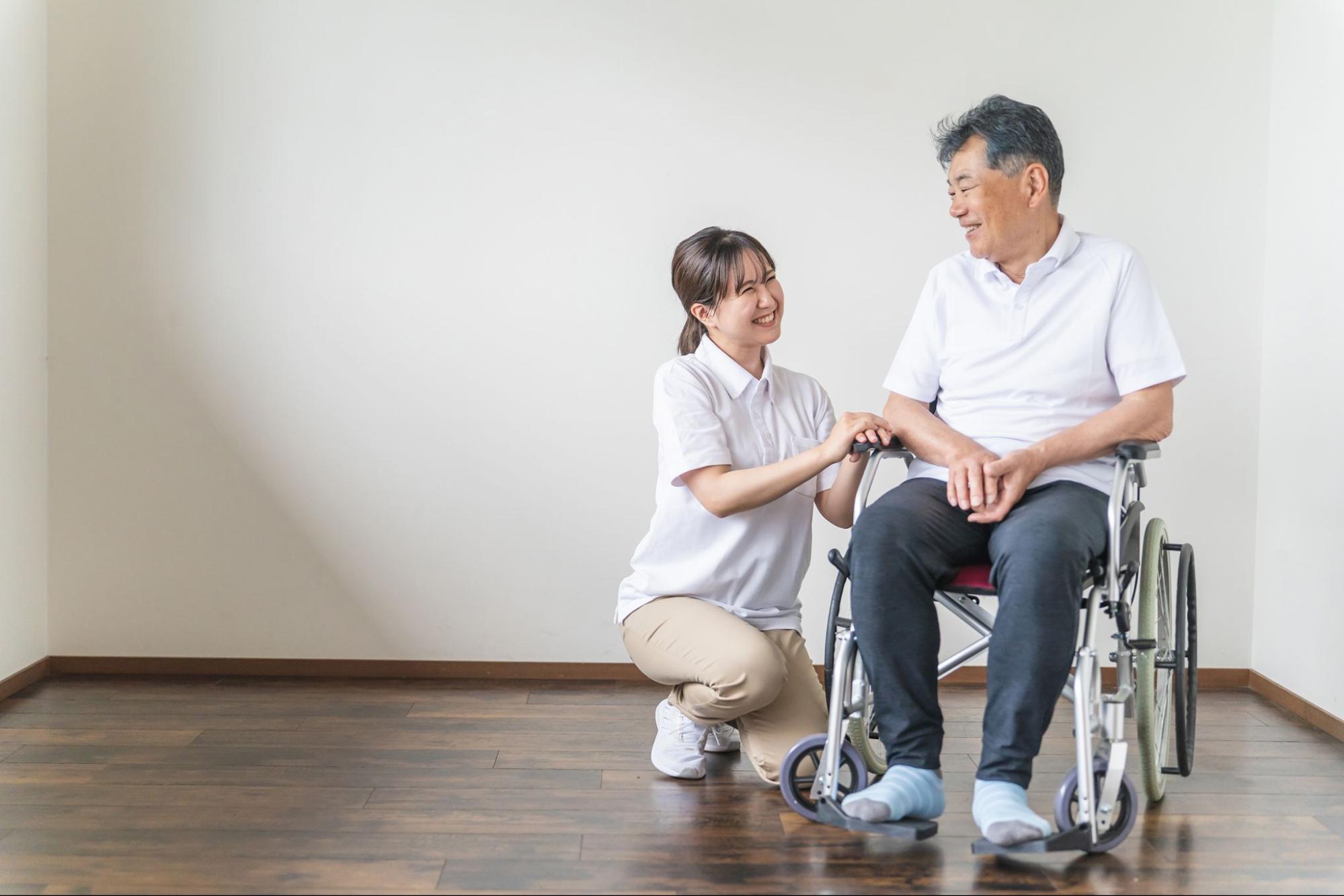 車椅子の利用者に寄り添う介護士