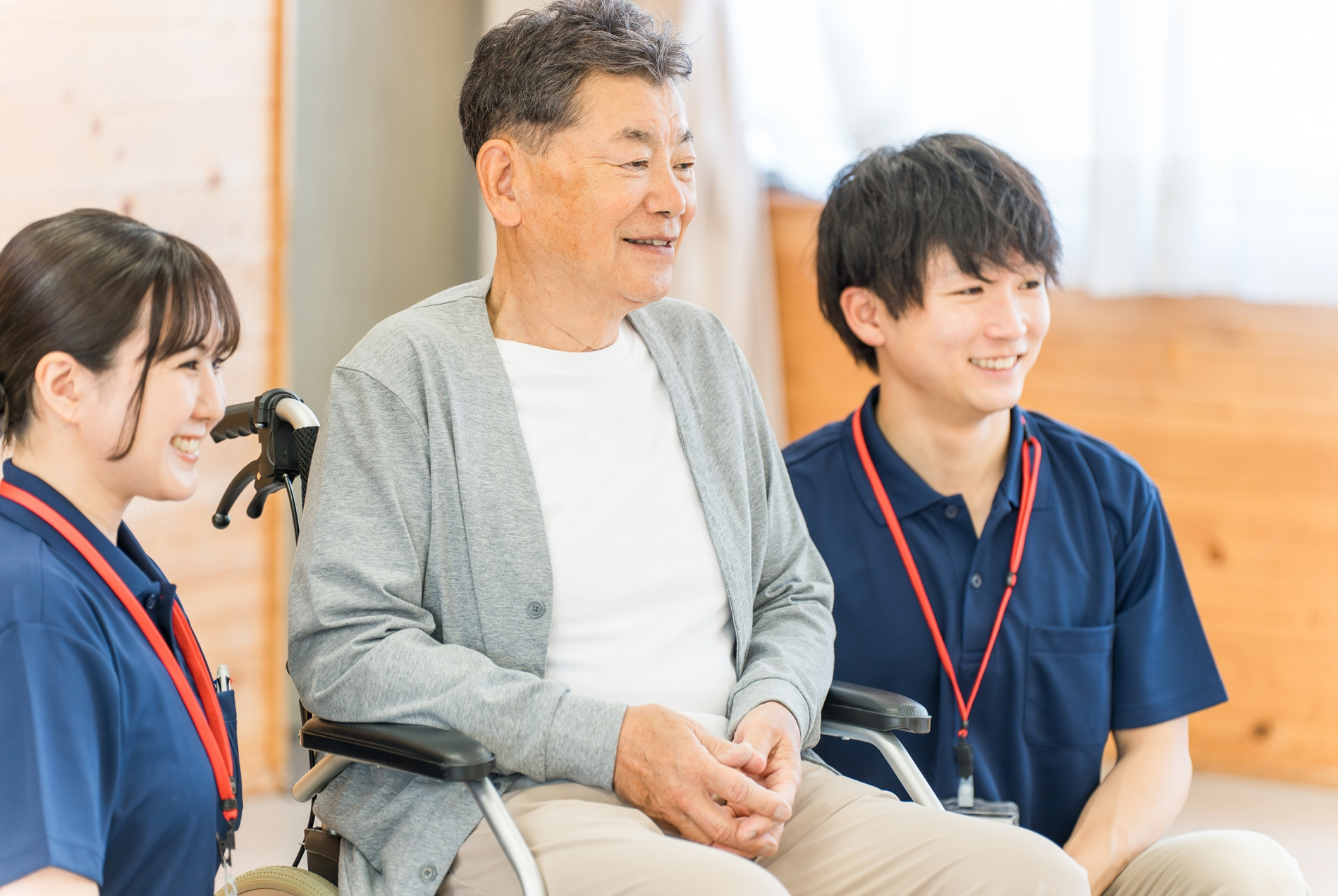 車椅子の男性と男女の介護士
