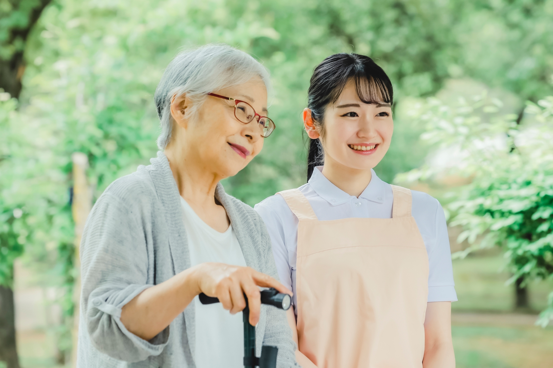 高齢者女性と女性スタッフ(新緑)