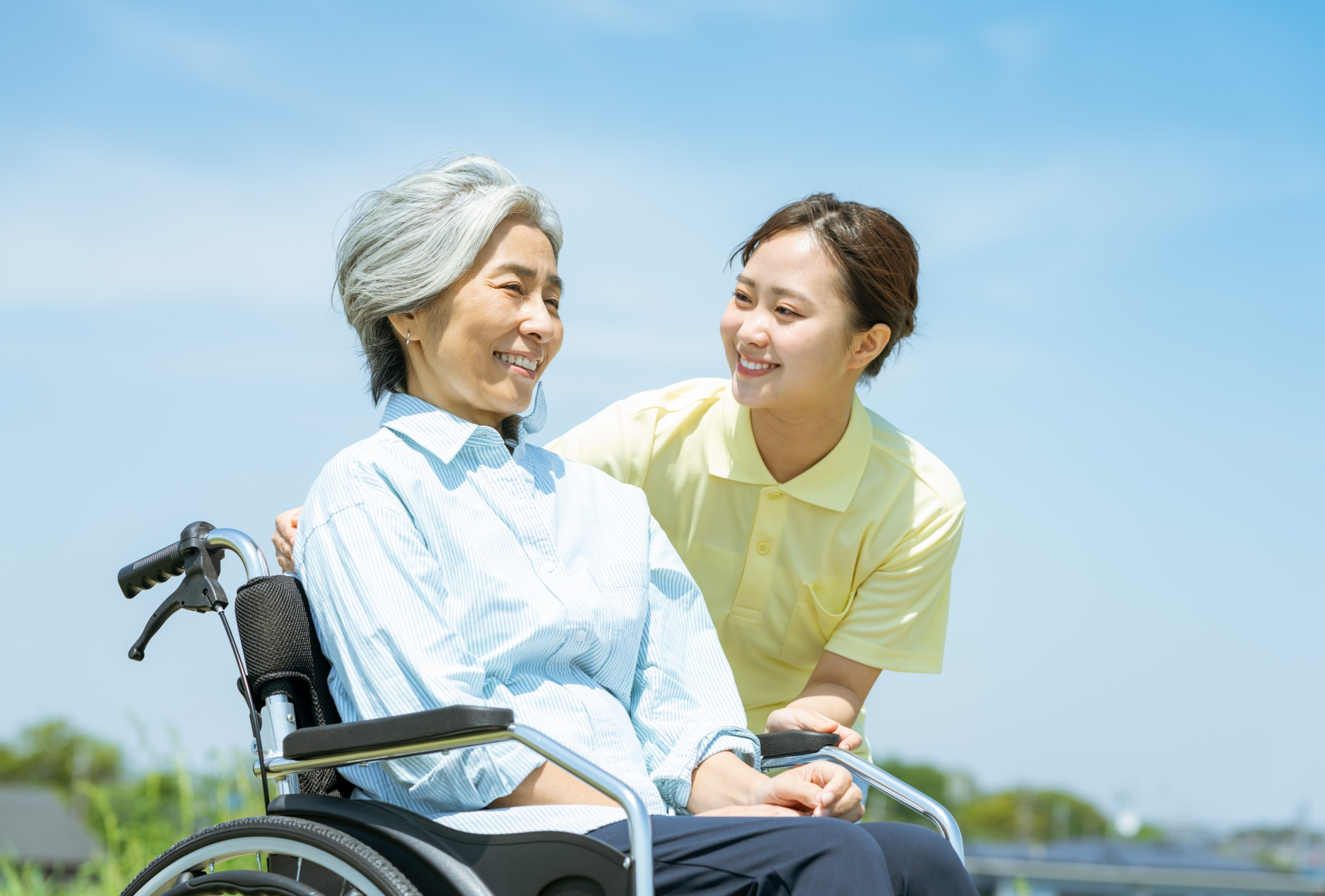 車椅子のシニアと介護士