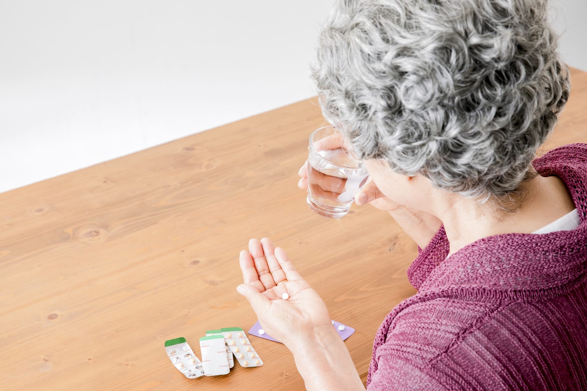 薬を飲む高齢者の女性