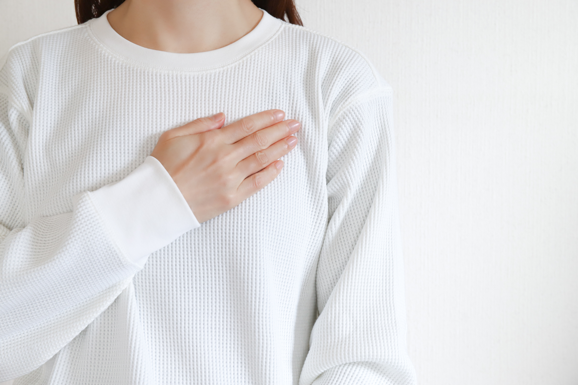 胸に手を当てる女性