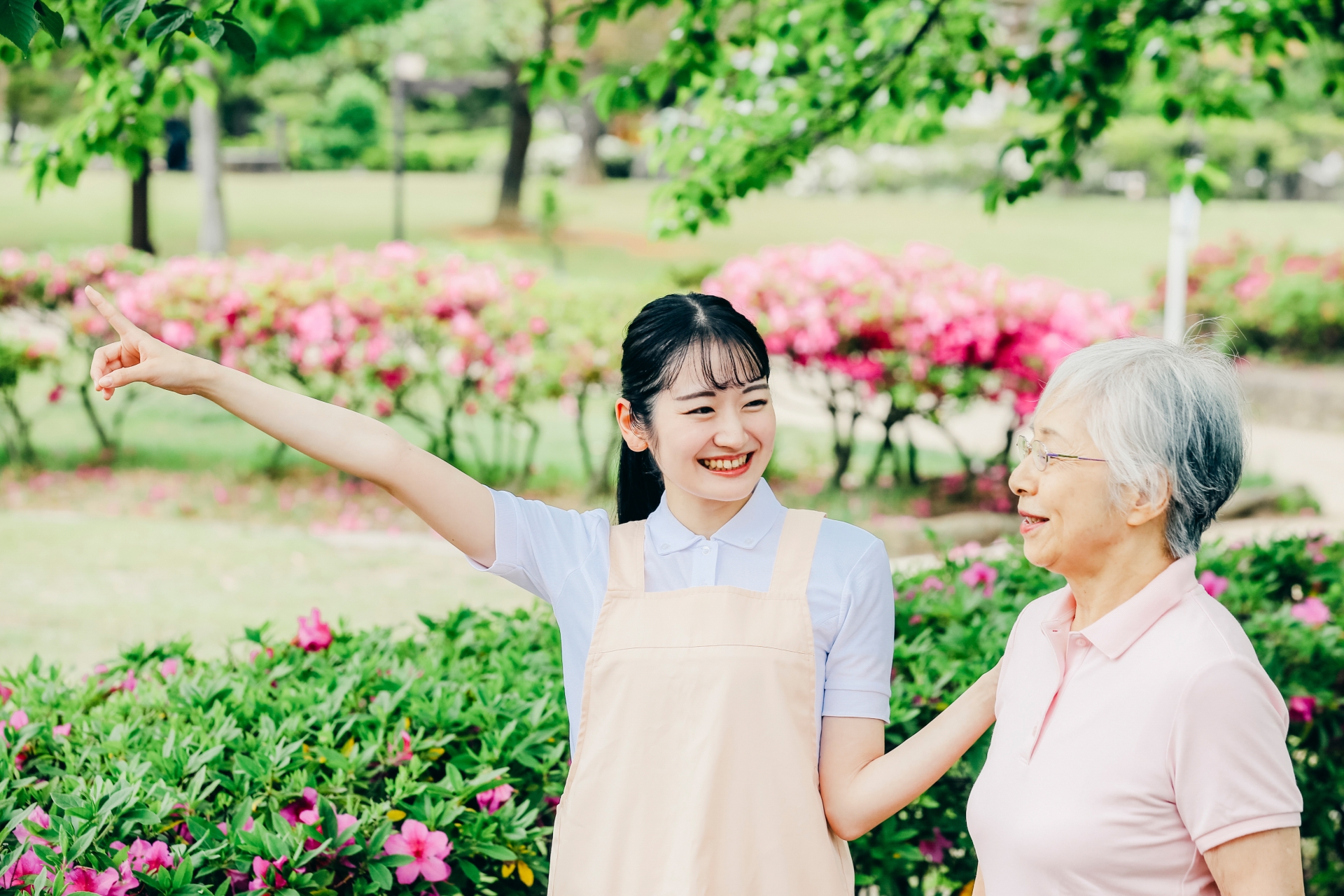 庭を高齢者と一緒に歩く介護士