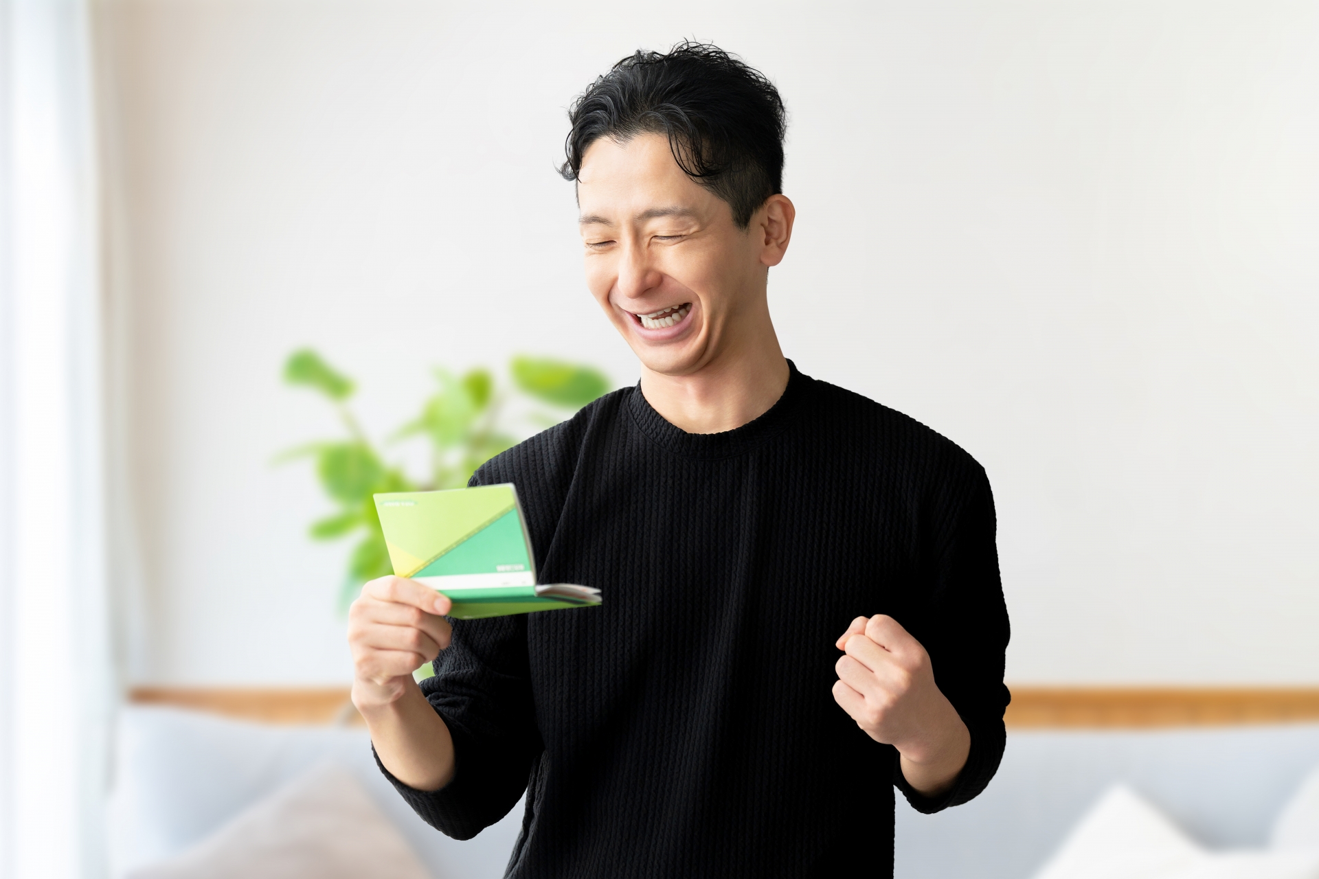 通帳を見て喜ぶ男性