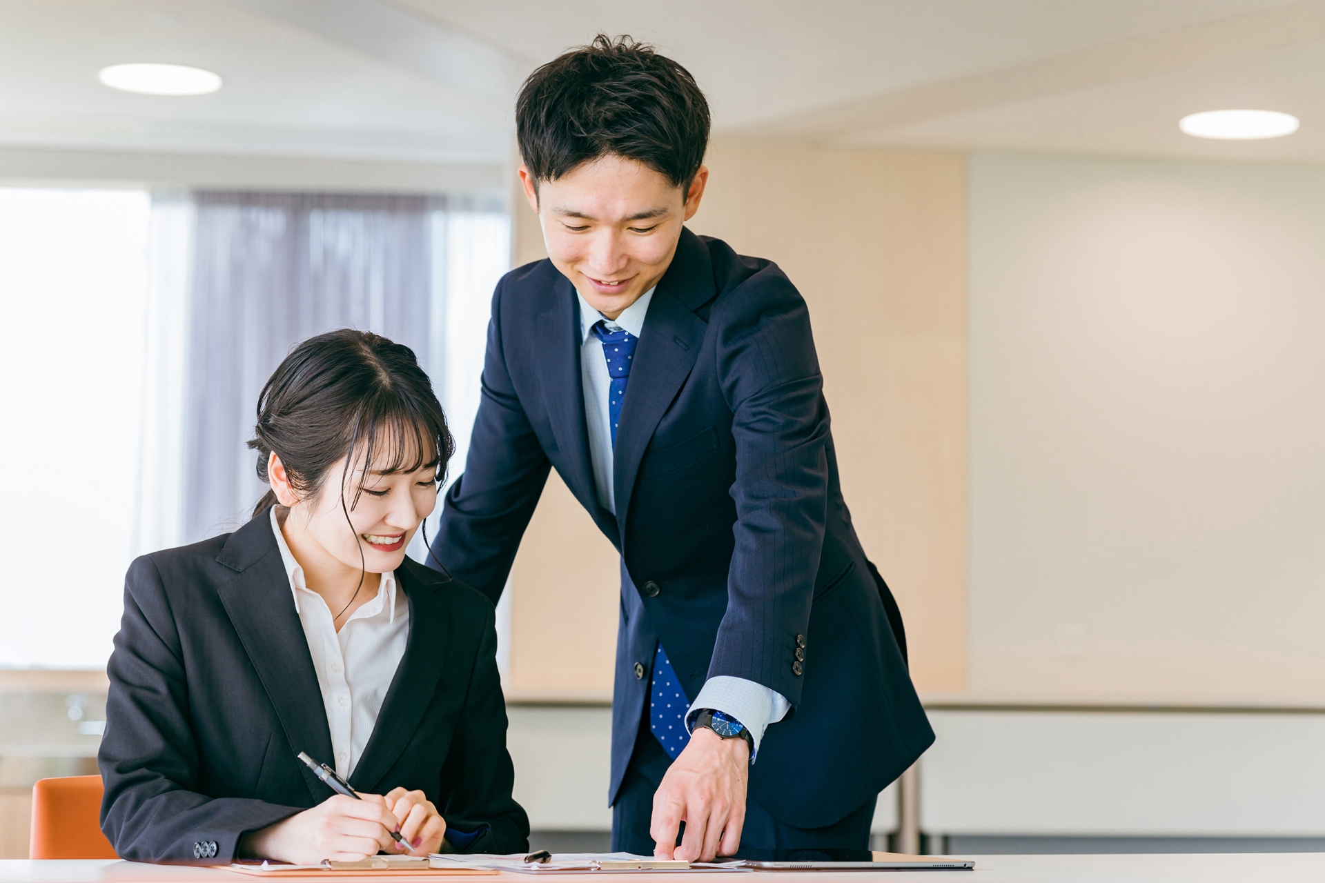 資料を見るスーツの男性と女性