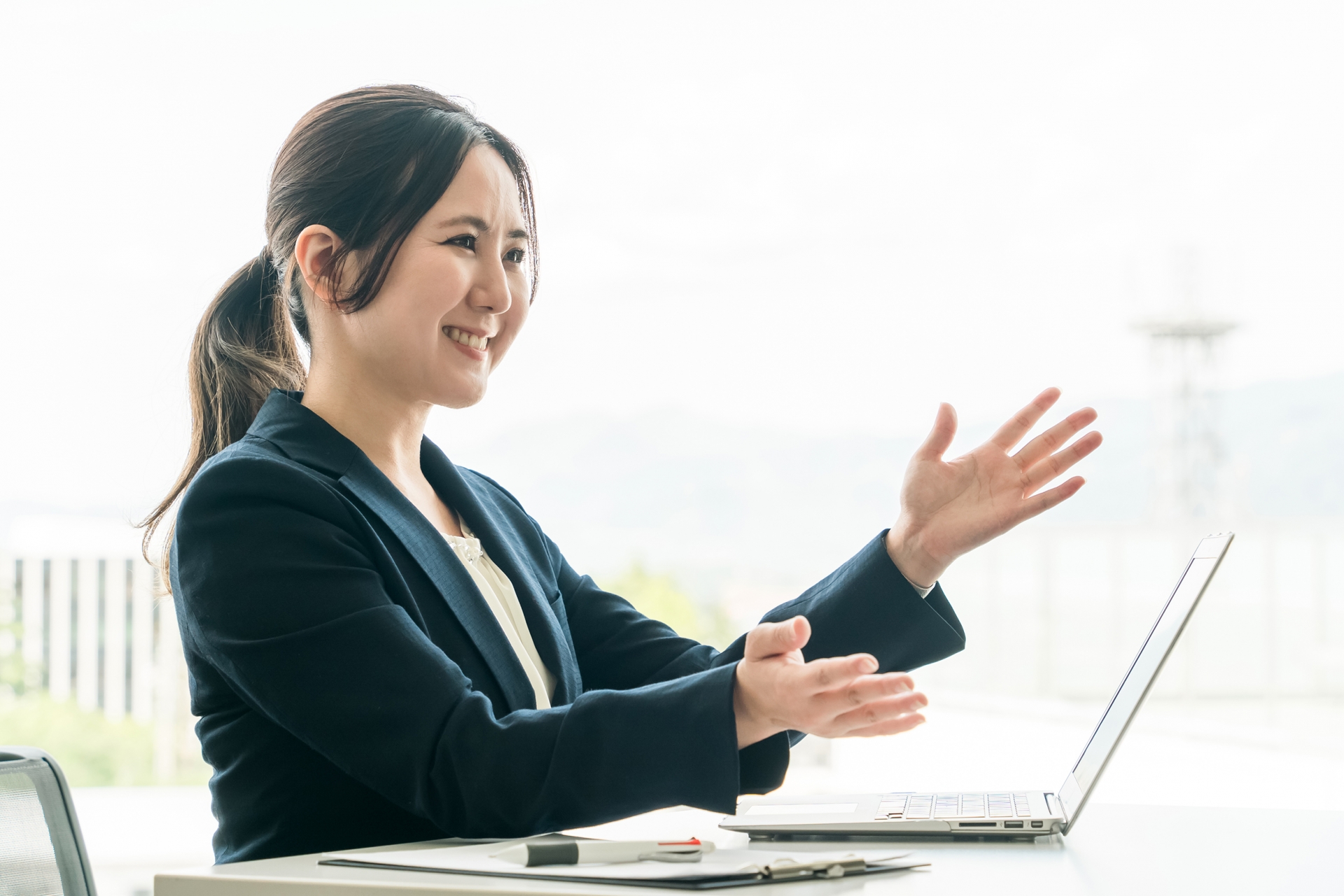 スーツを着た笑顔で説明する女性