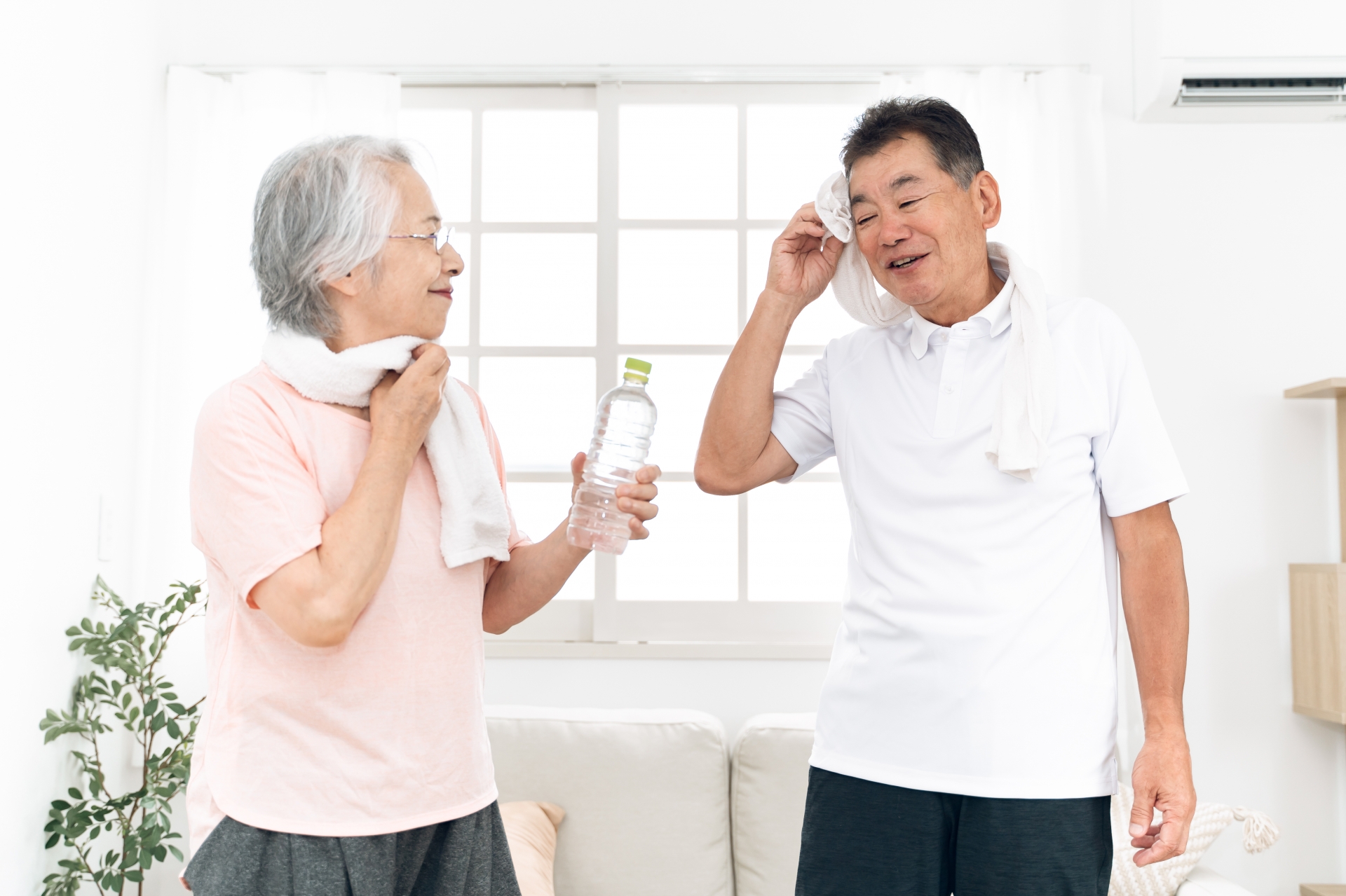 タオルで汗を拭う高齢者の男女