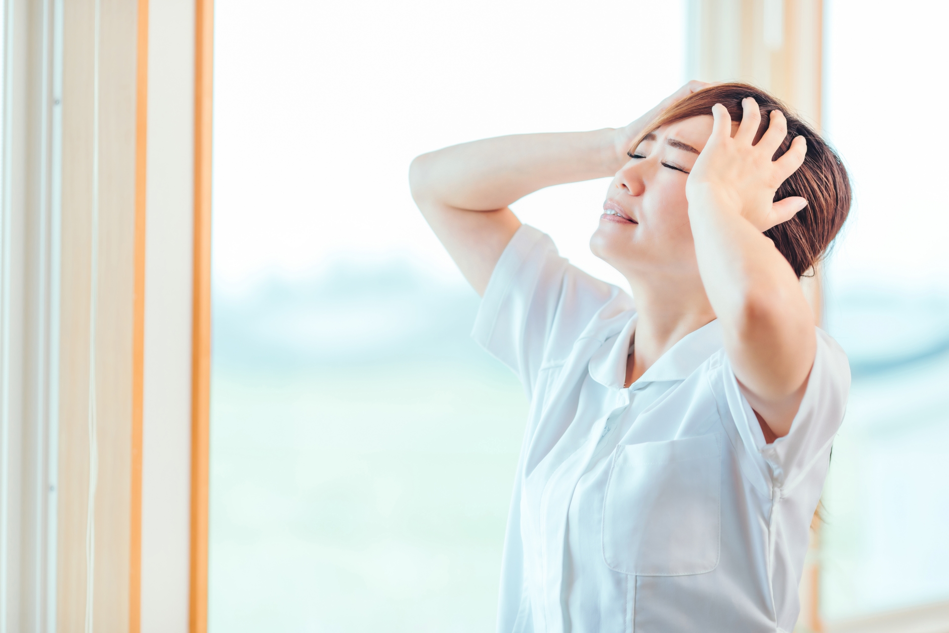 頭を抱え込む白衣の女性