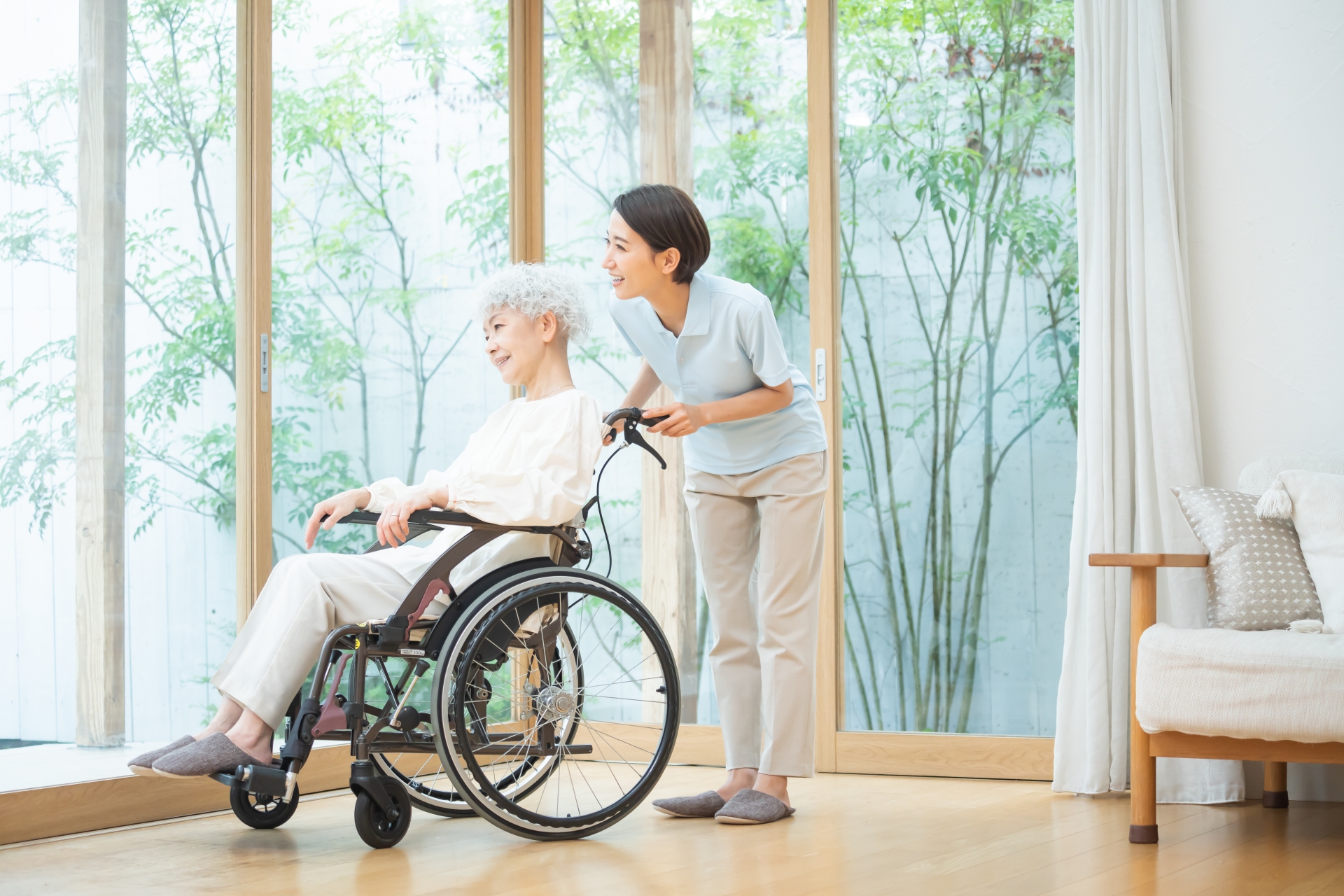 居室で車椅子を押す介護士