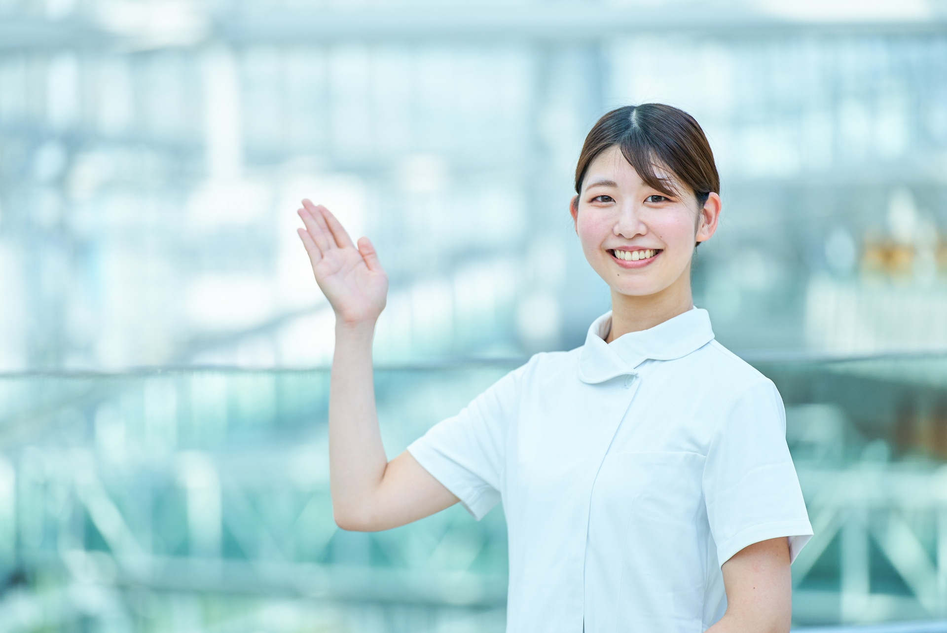 手を挙げて案内をする看護師