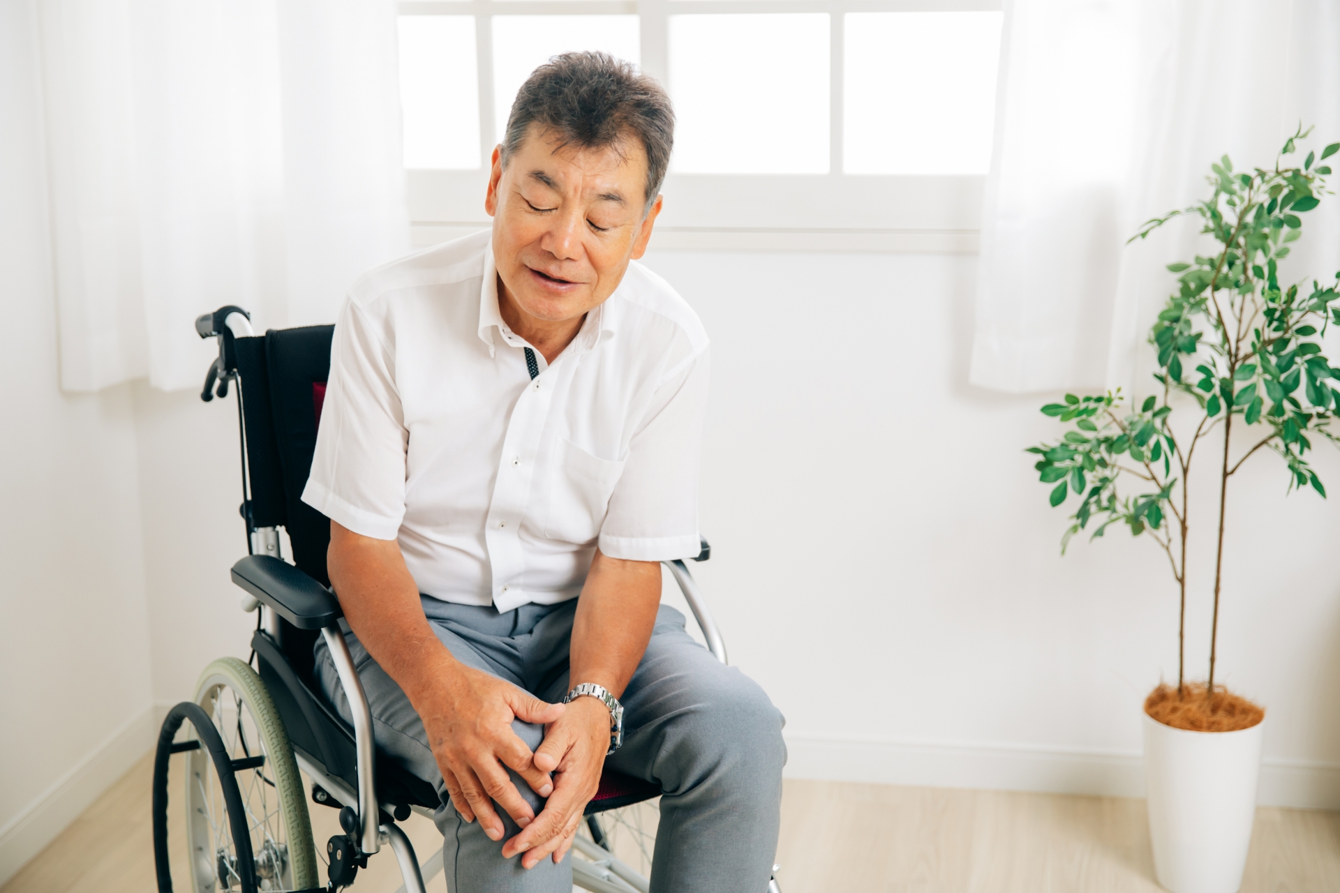 膝を触る車椅子の男性