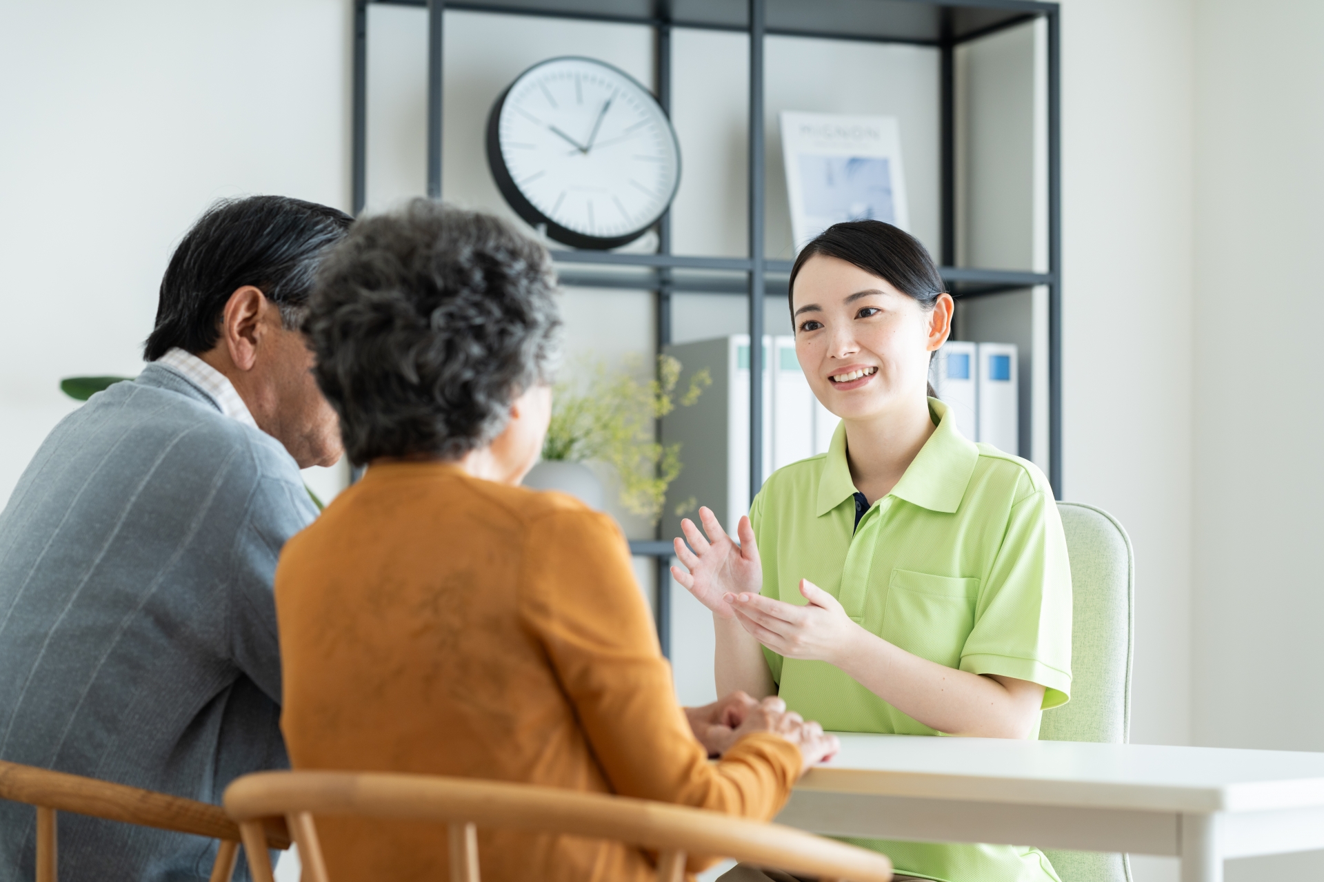 高齢夫婦と話をする介護士