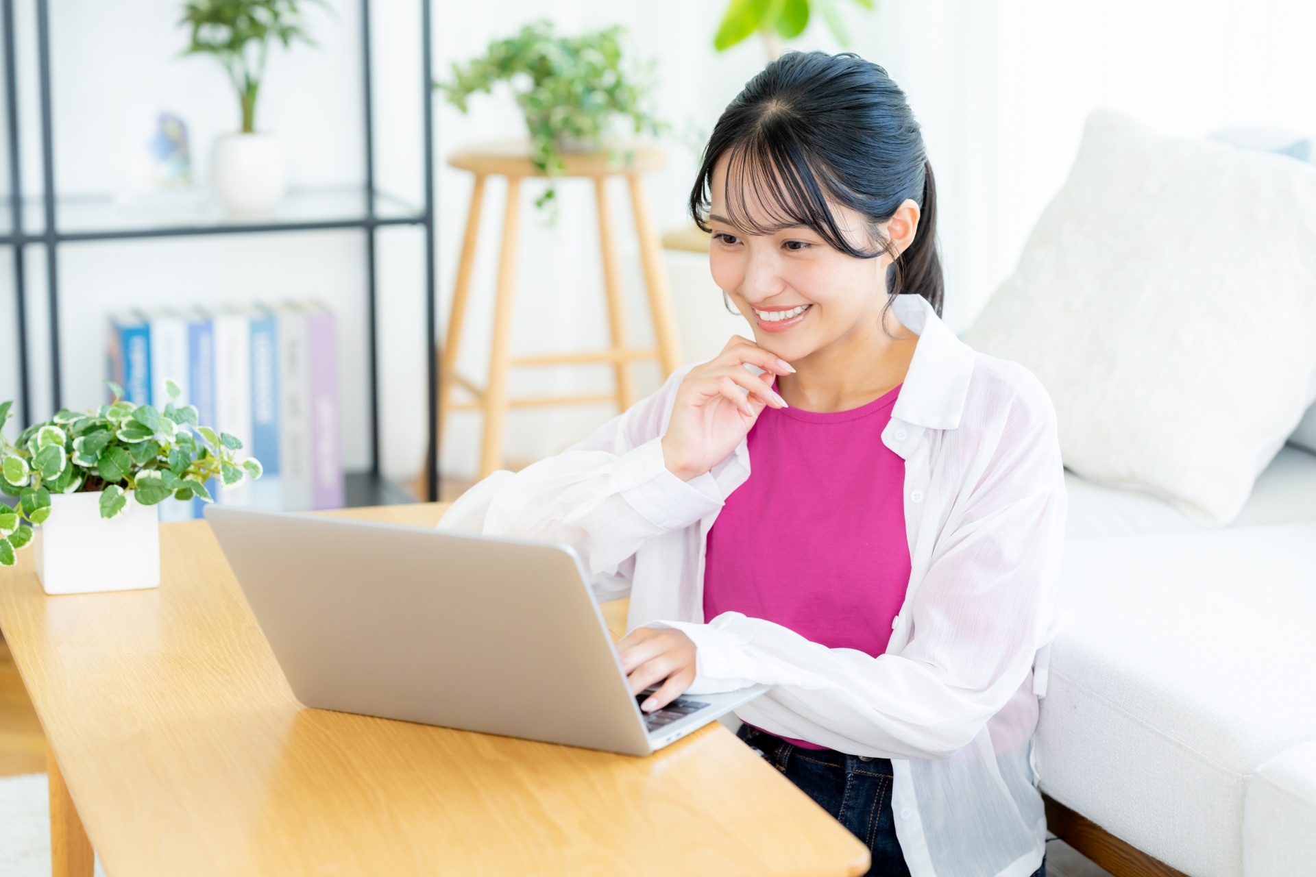 リビングでパソコンを見る若い女性