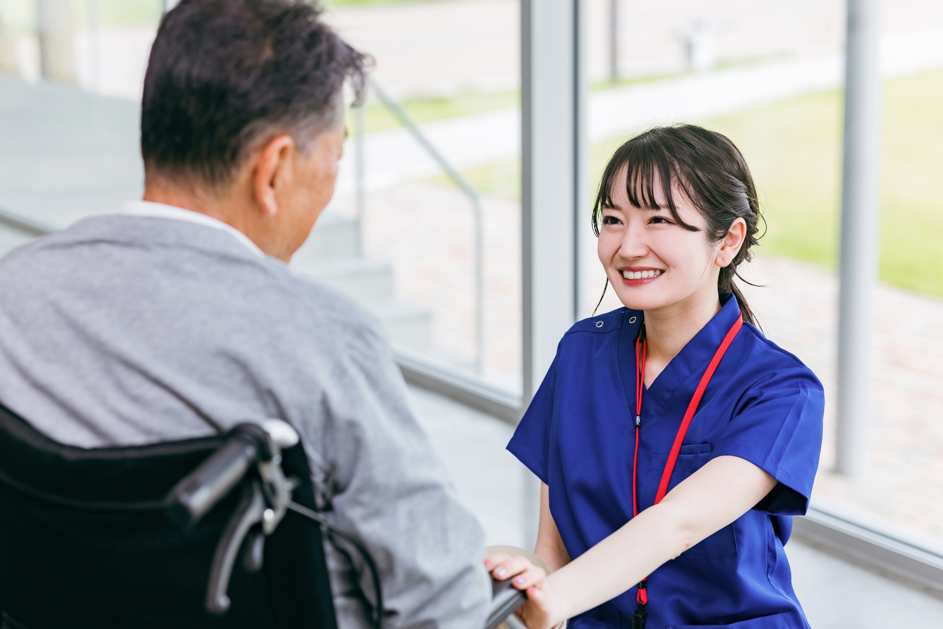 車椅子の男性と笑顔で話す女性