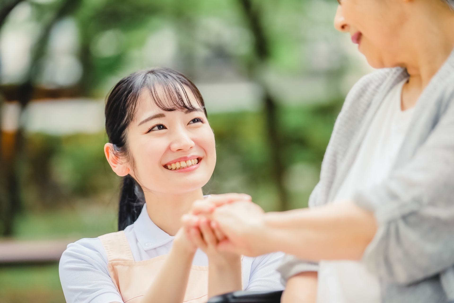 下から車椅子の女性を見つめる女性