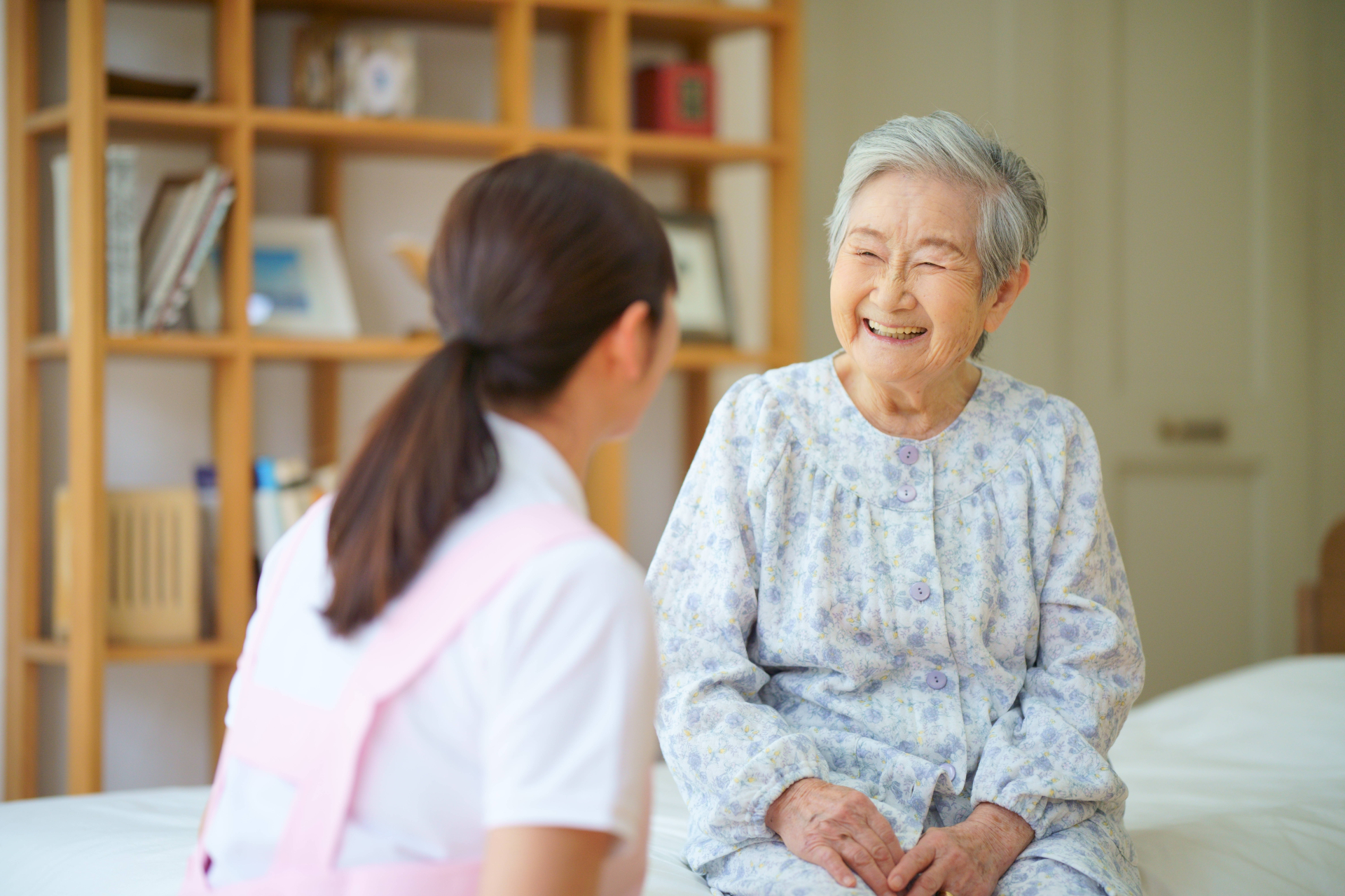 笑顔の高齢者と寄り添う介護士