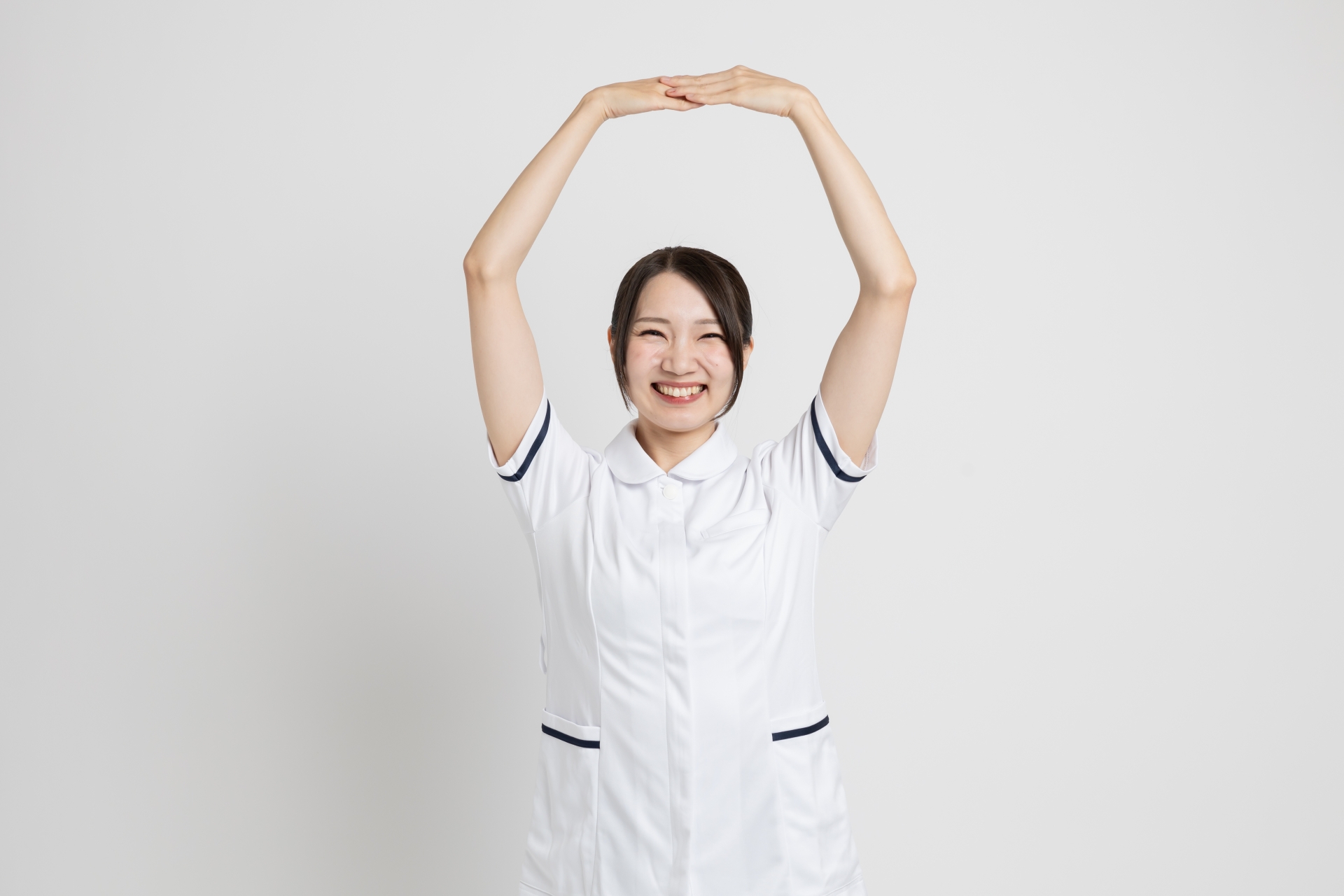 大きく両手で丸サインをする白衣の女性