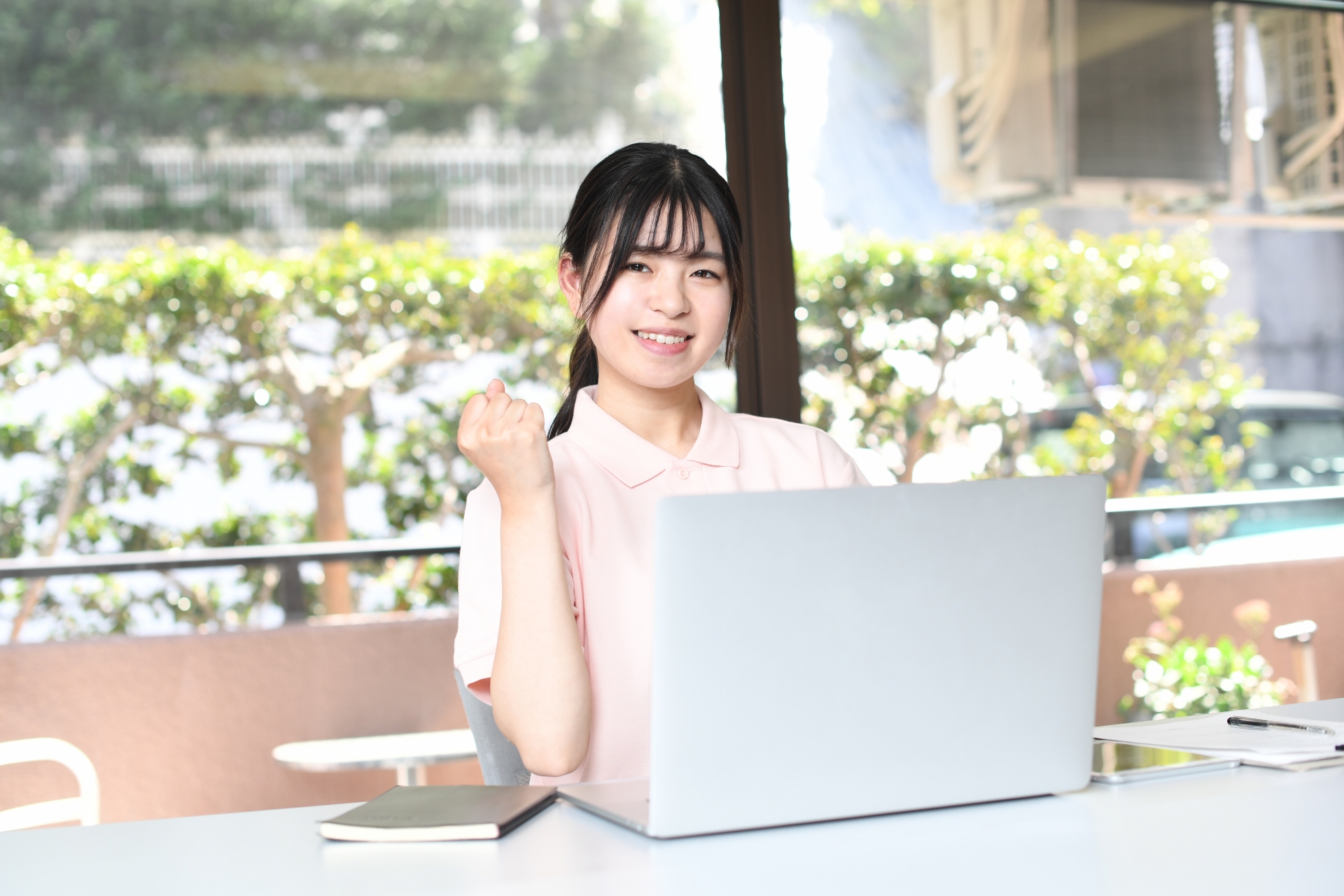 ノートPCの前でガッツポーズをする女性