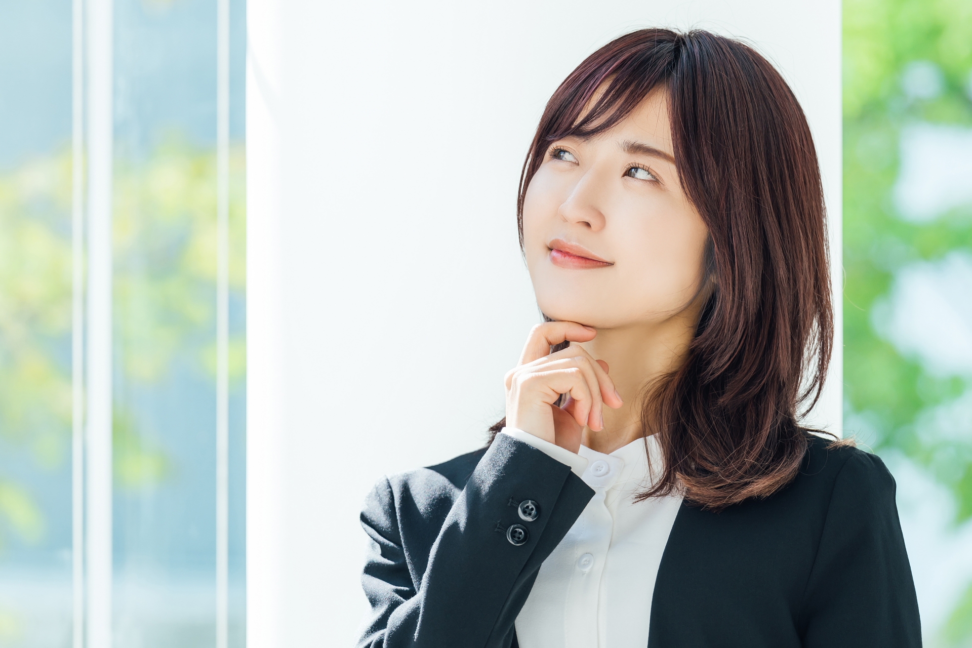 微笑みながら考えるビジネスウーマン