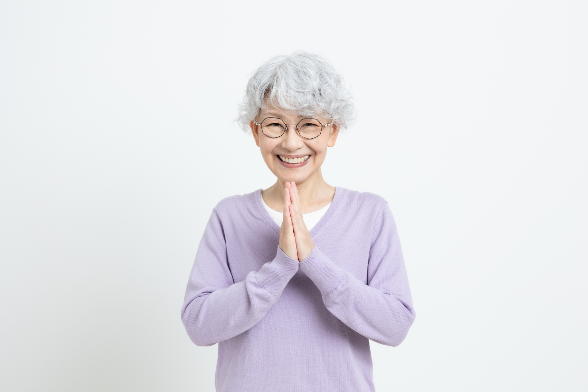 手を合わせて喜んでいるシニア女性