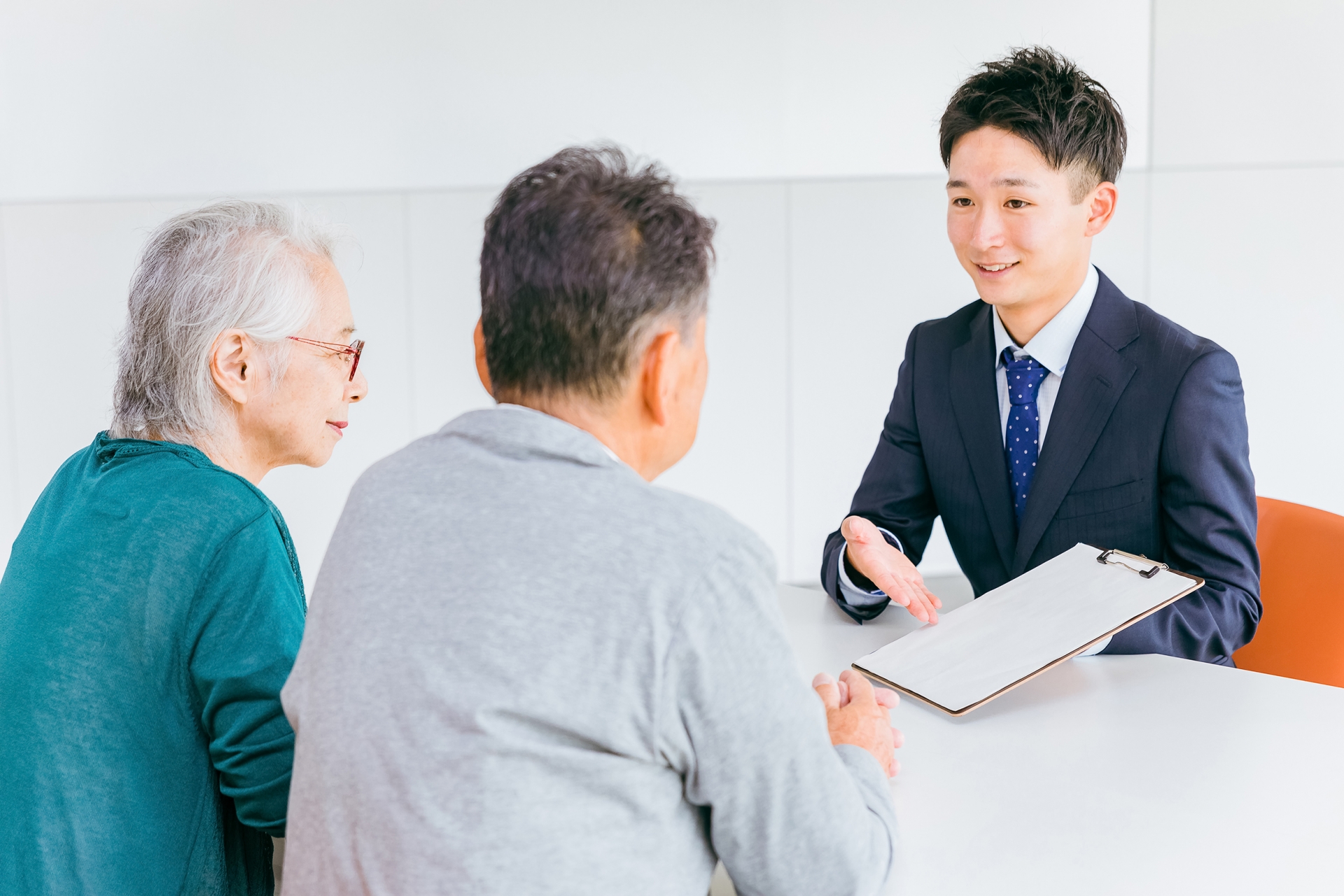 高齢者夫婦に書類の説明をするビジネスマン