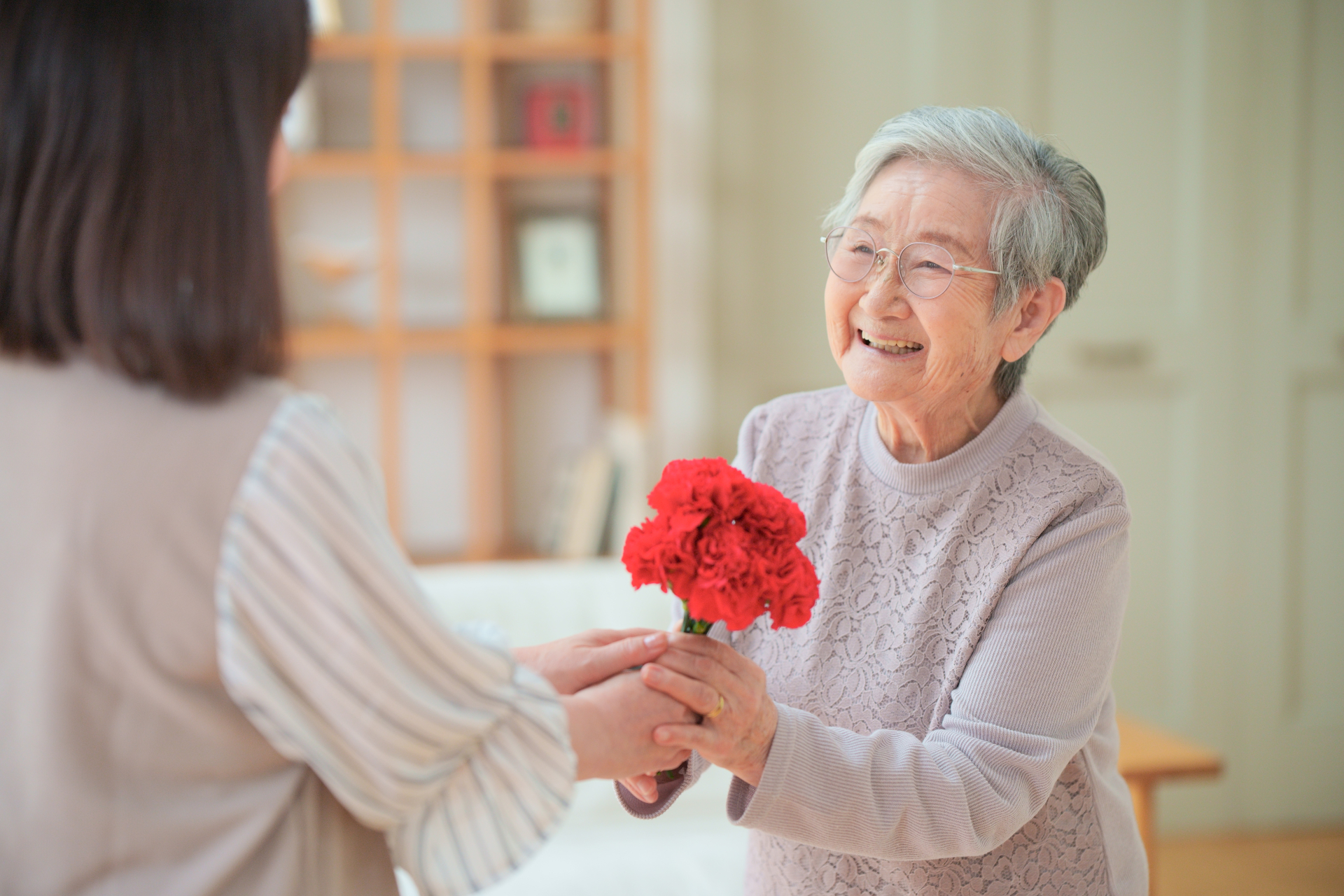 花を貰い笑顔の高齢女性