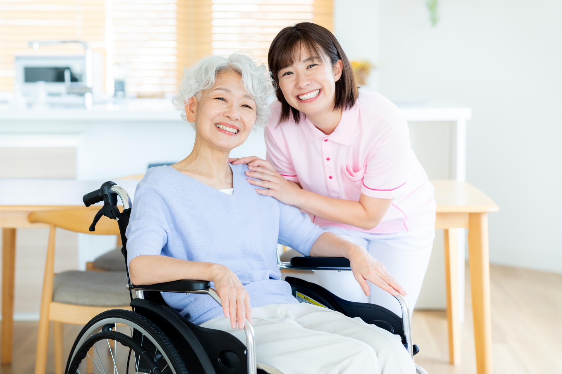 車椅子に乗った女性をサポートする介護士