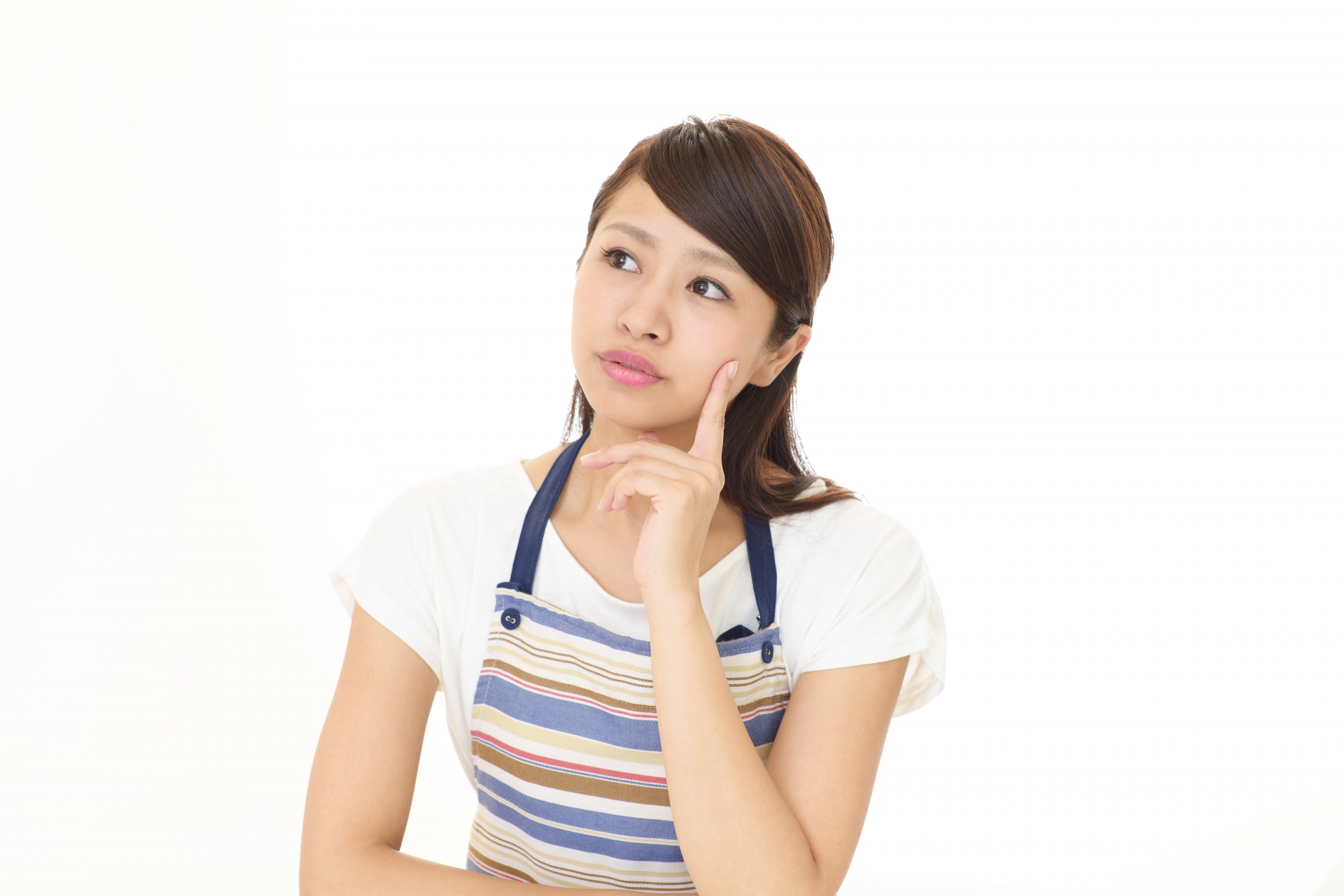 考え事をするエプロンをつけた女性