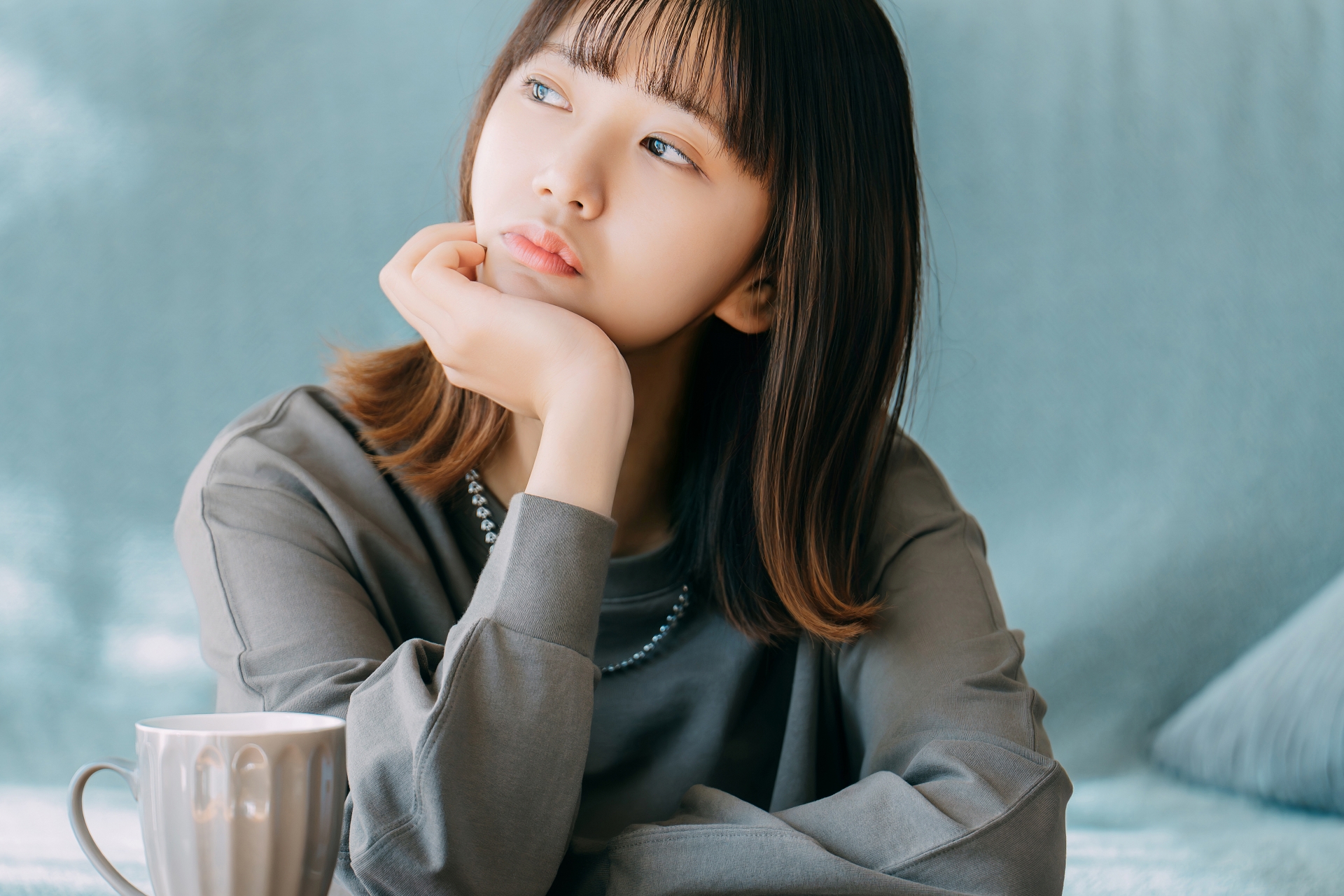 肘をついて考え事をする女性