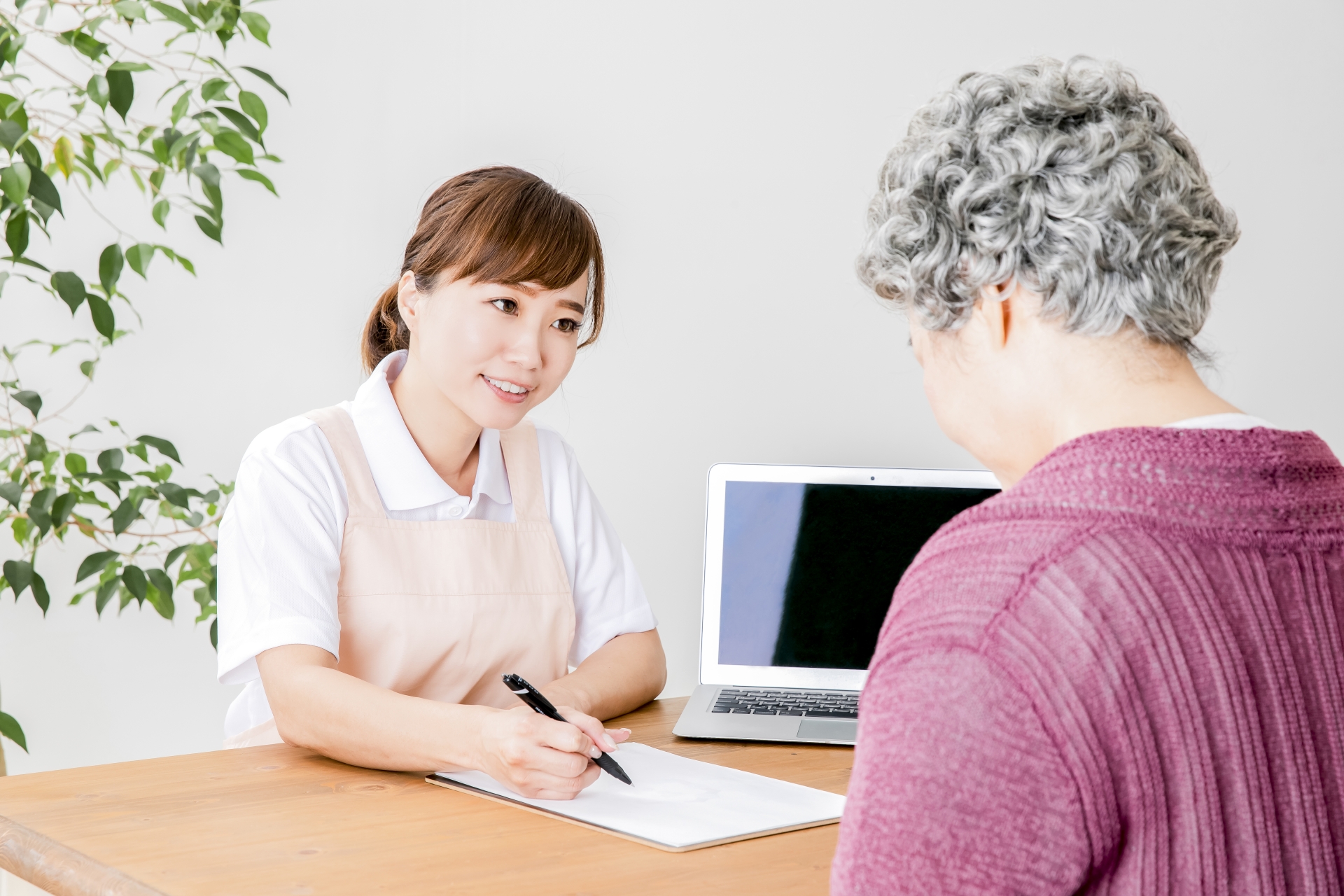 説明する介護士と高齢者の女性