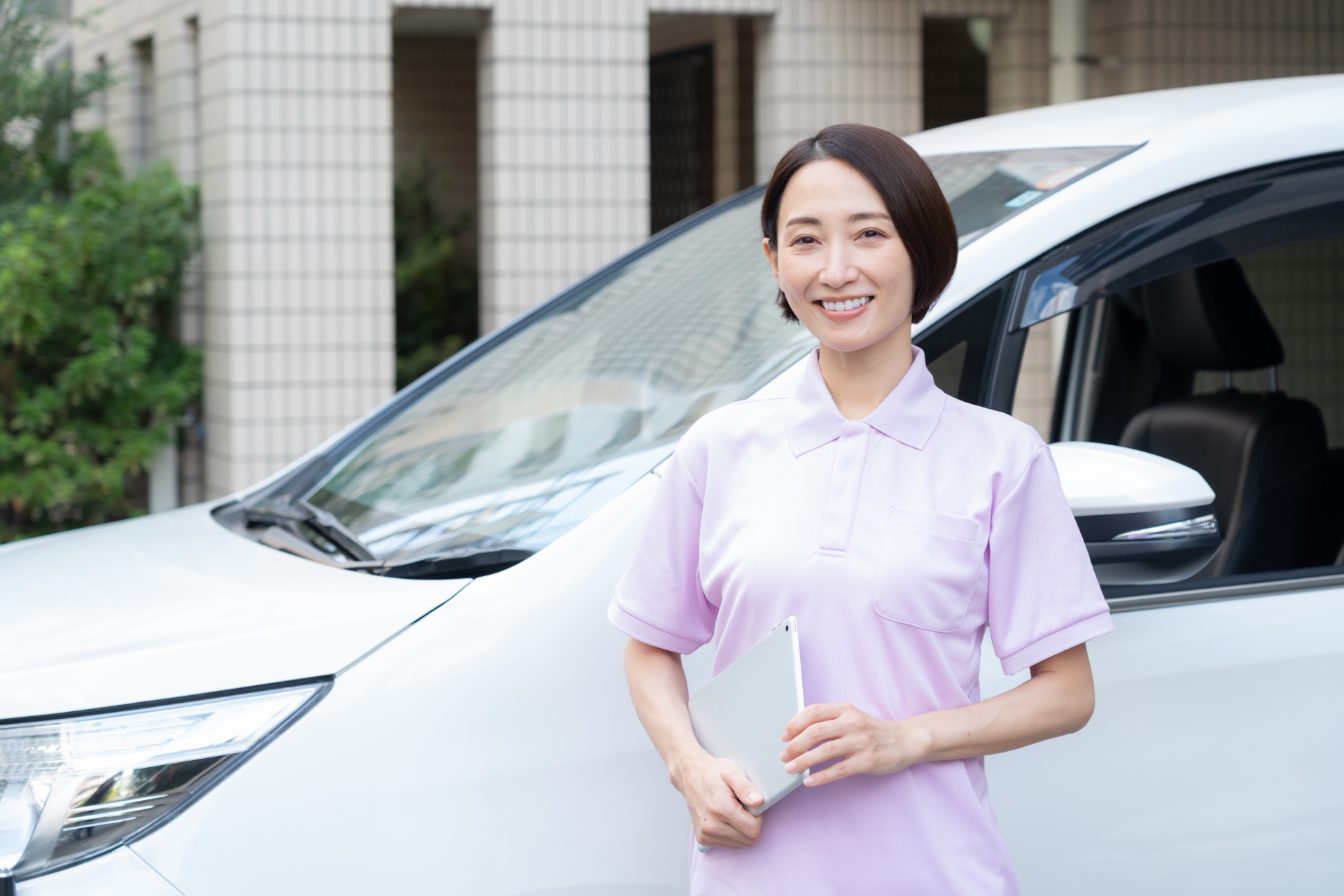 車で訪問介護をするミドルの女性介護士