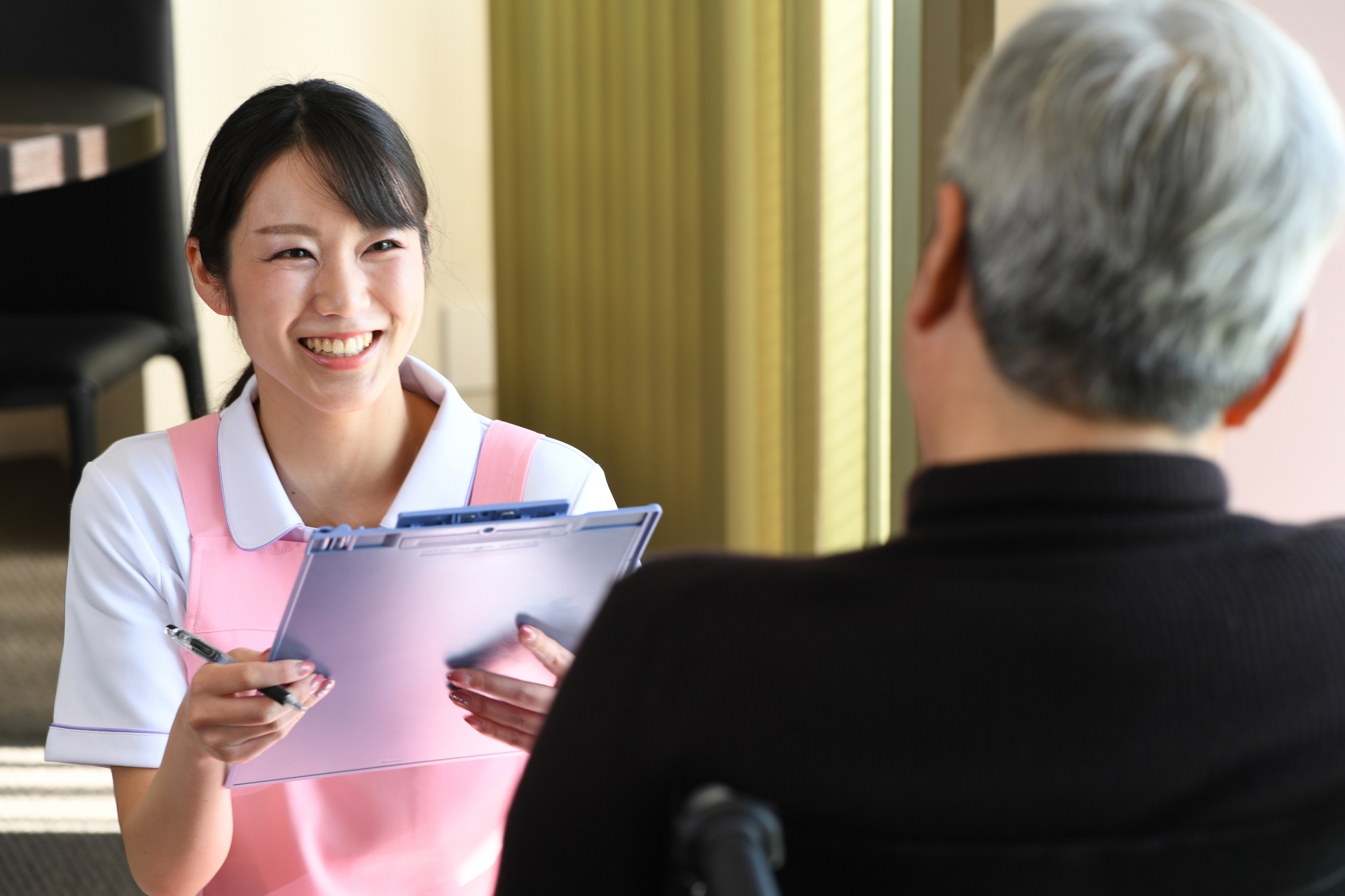 カウンセリング（問診）をする介護士とシニアの男性
