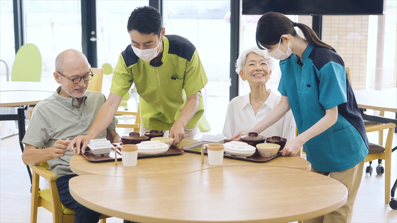 高齢者に食事を提供する介護スタッフ