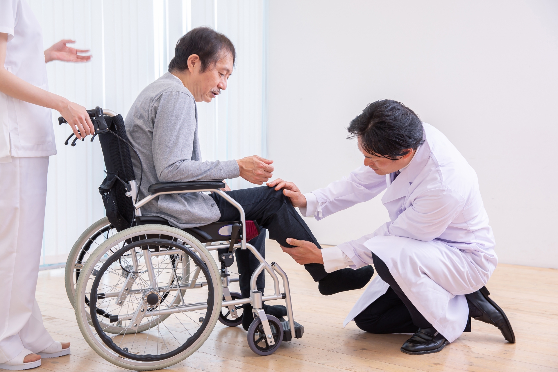 車椅子に乗る患者と医者（足）