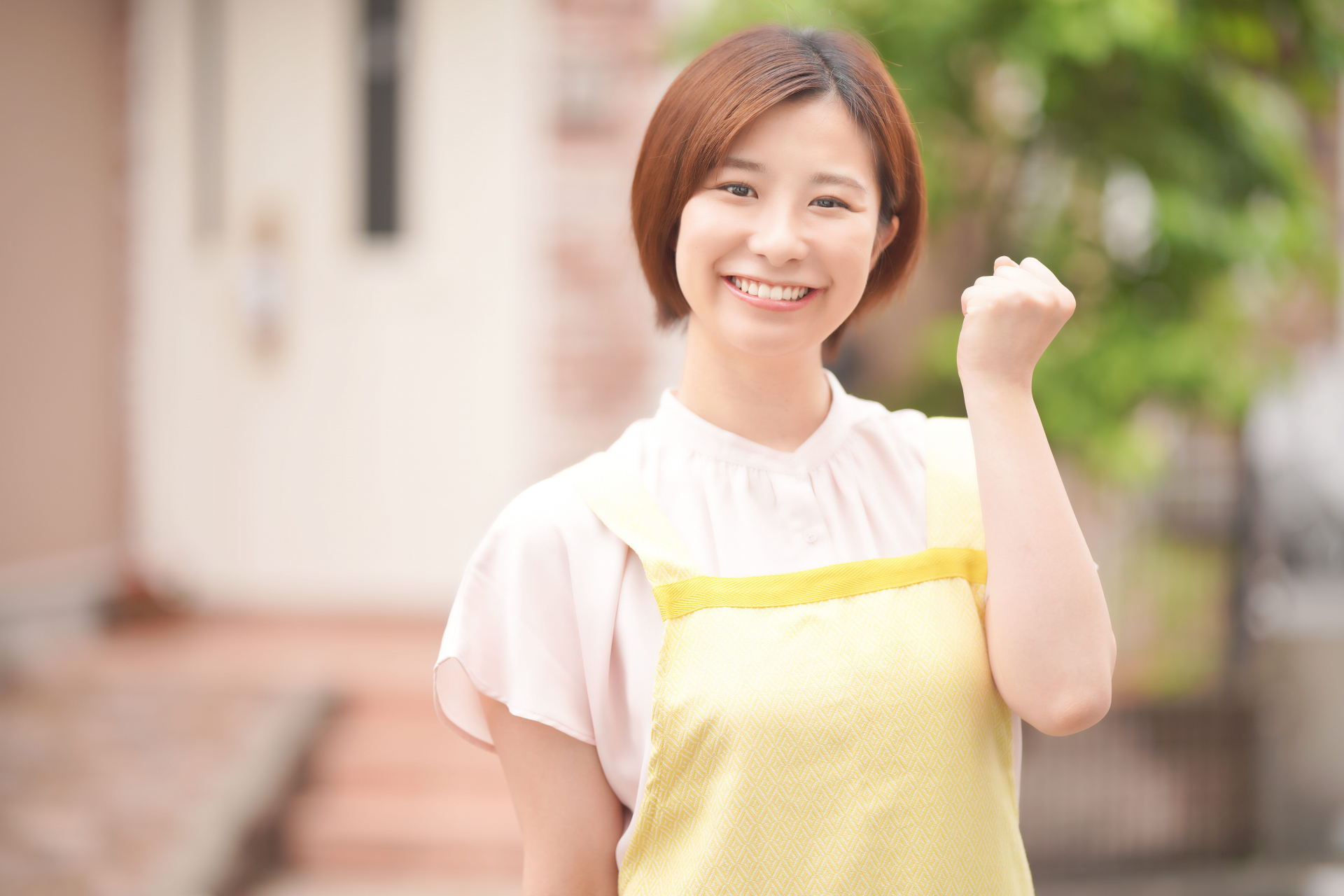 ガッツポーズをするエプロンをつけた女性