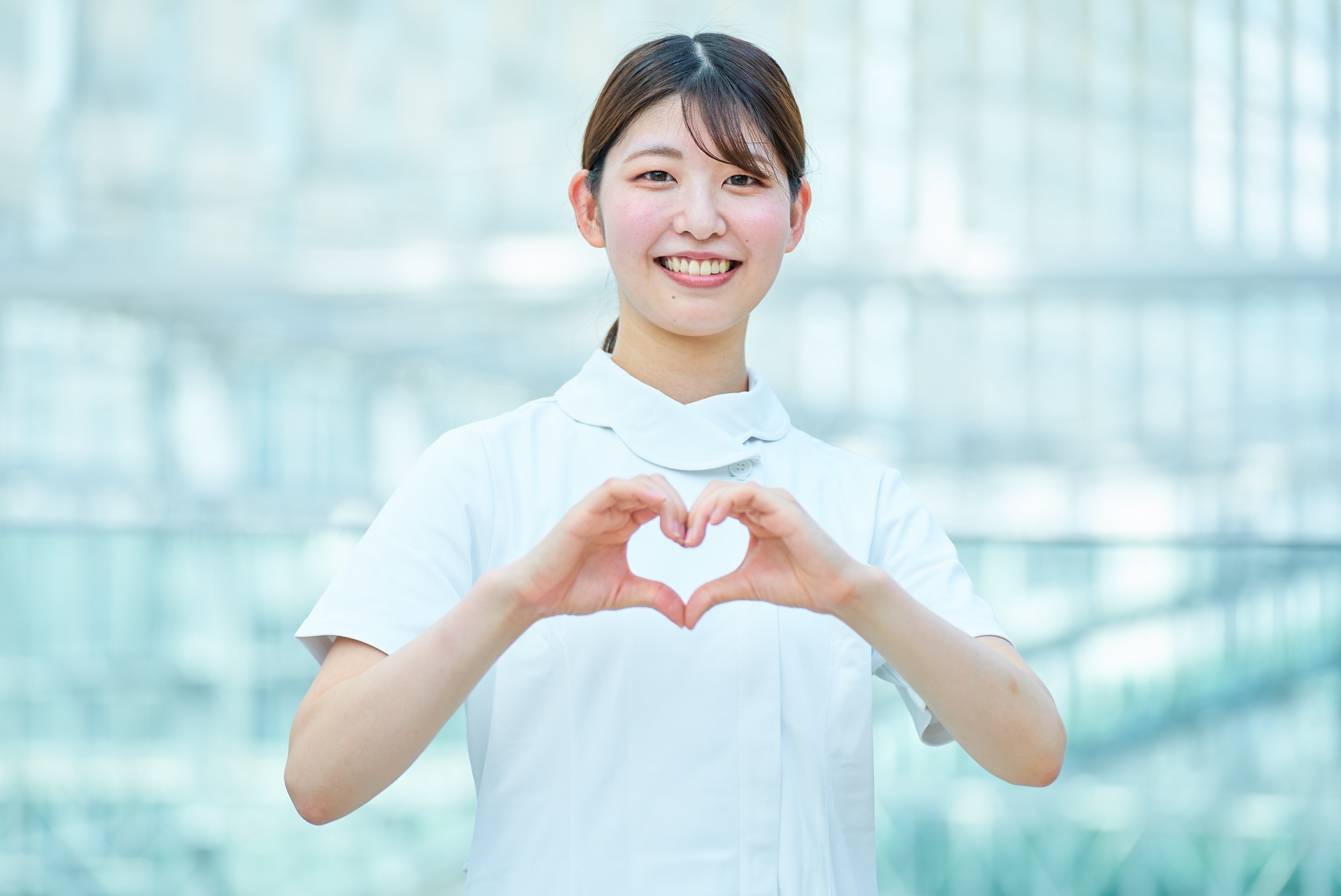 ハートマークを作る白衣の女性