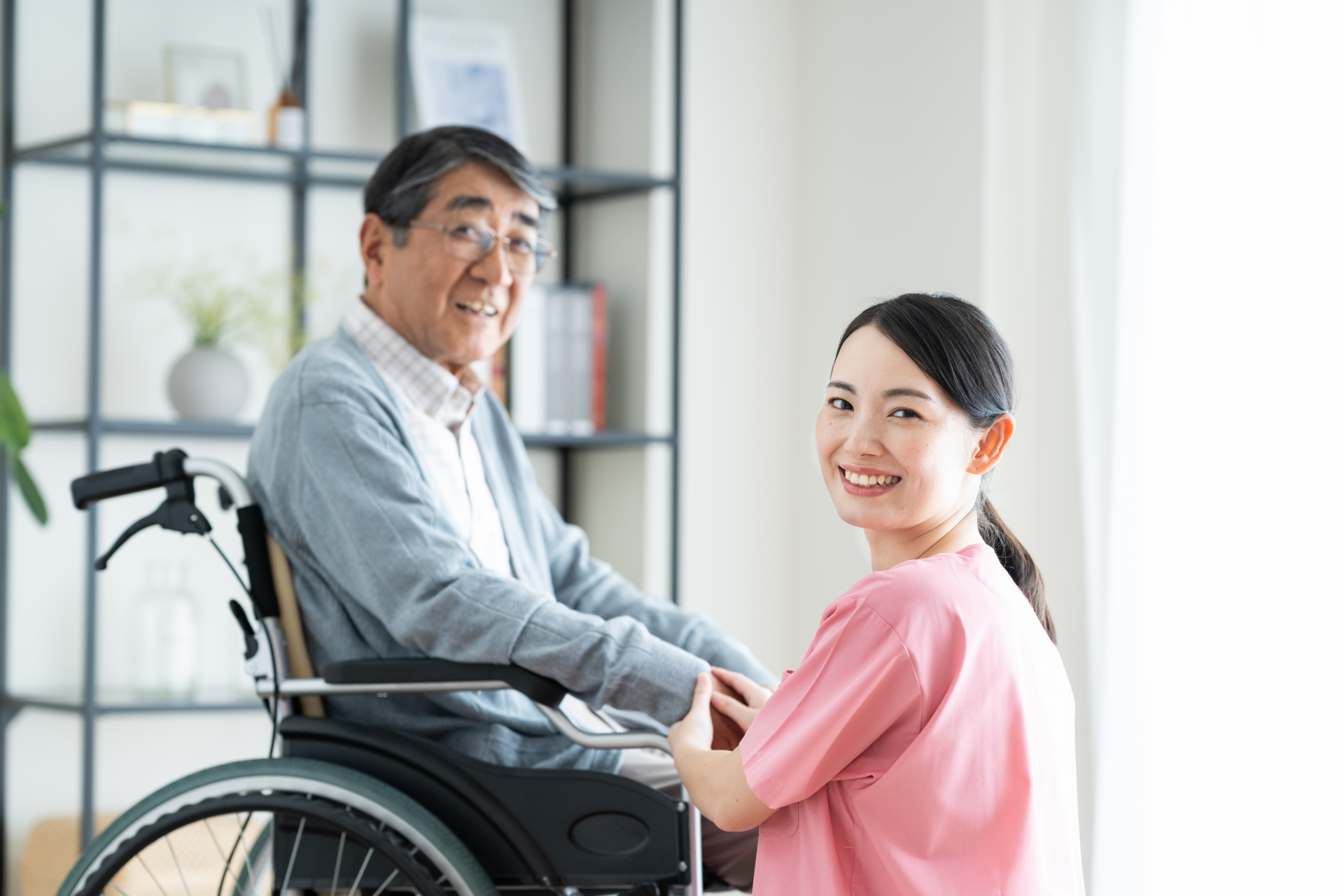 車椅子のシニアの男性と介護福祉士
