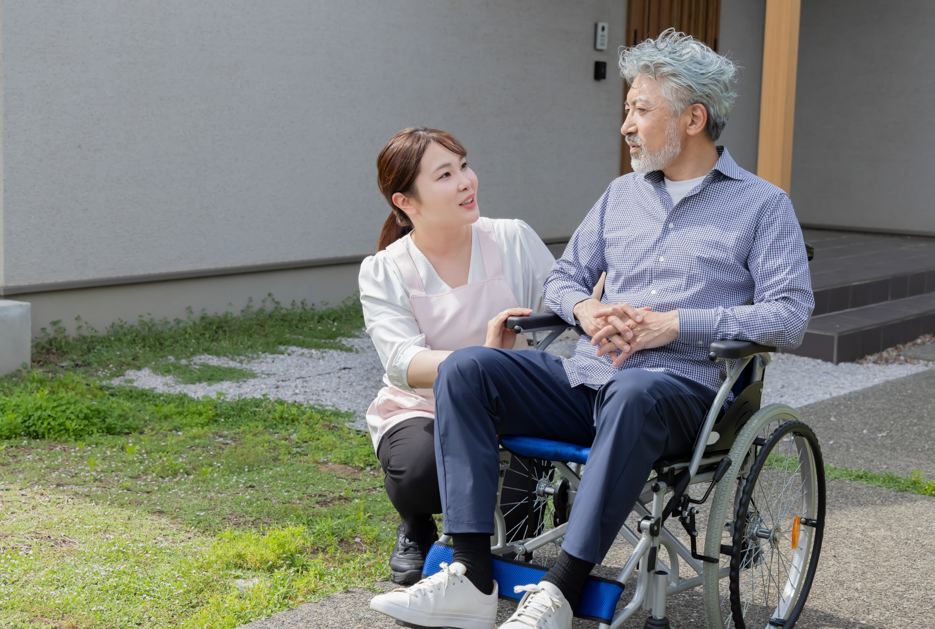 車椅子に乗るシニア男性と介護士