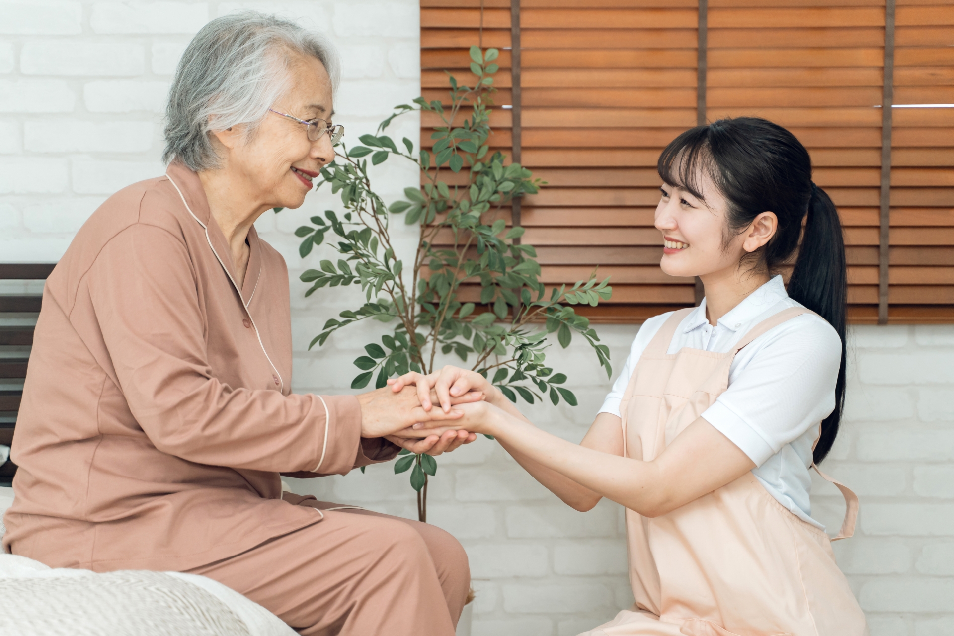 高齢者の手を握る介護士