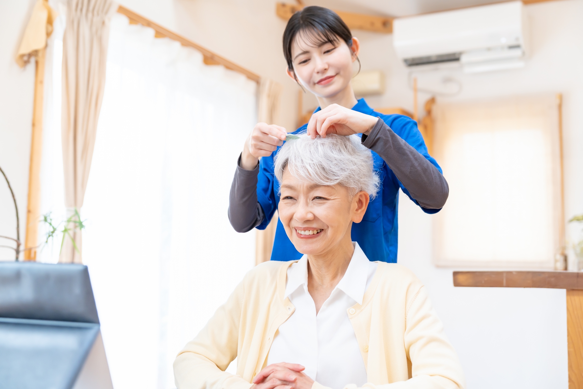 ヘアアレンジをする高齢者と介護士