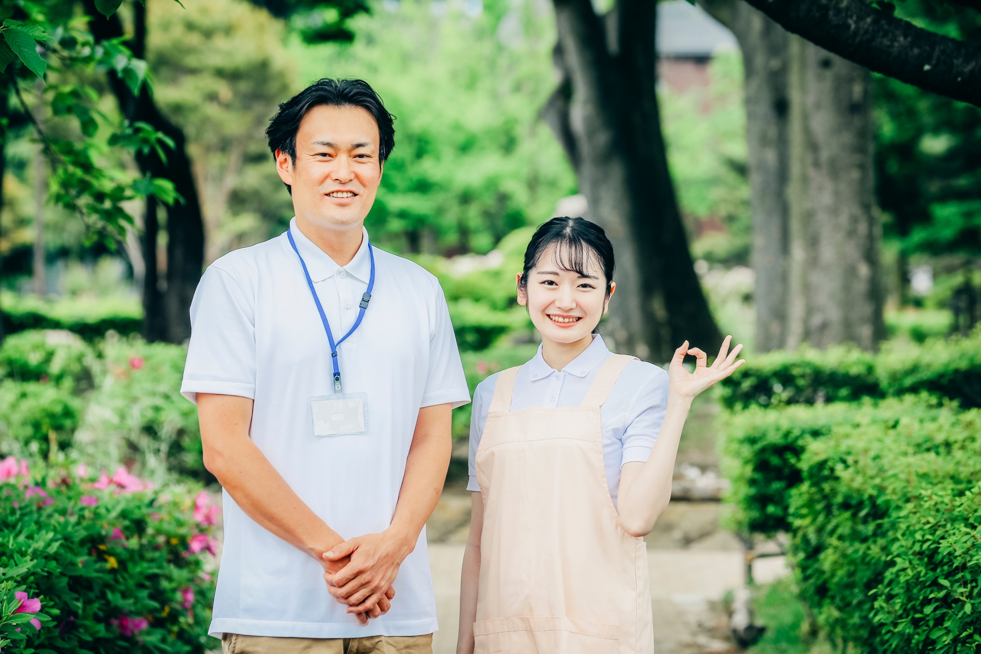 庭に立つ男女の介護士