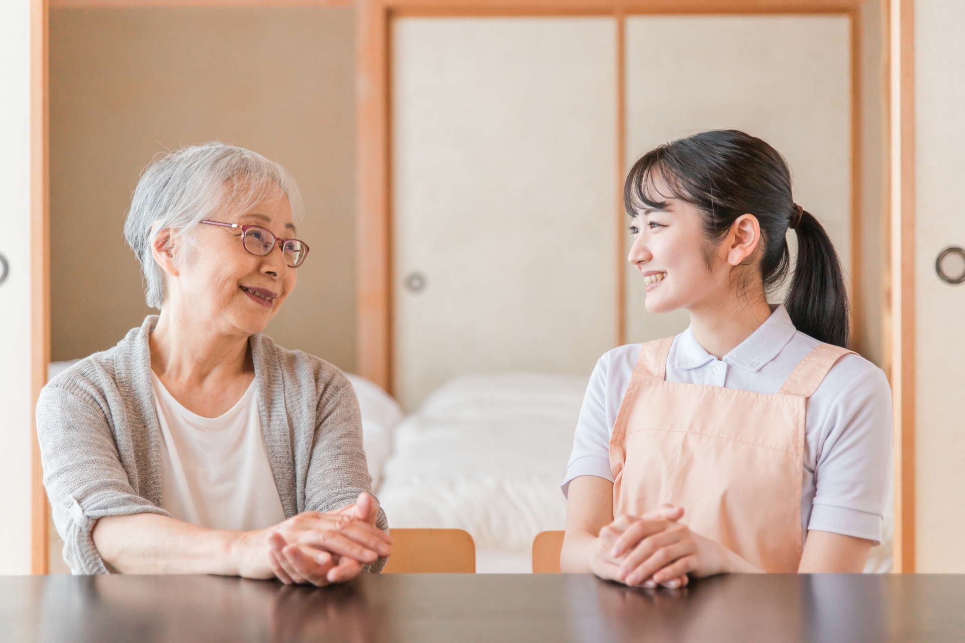 高齢者女性と話す女性スタッフ