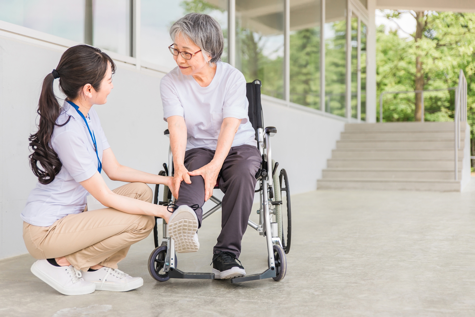 車椅子に乗る高齢者と介護士
