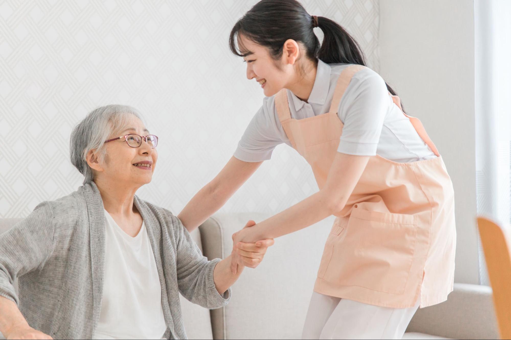 訪問介護する女性と高齢者（笑顔）