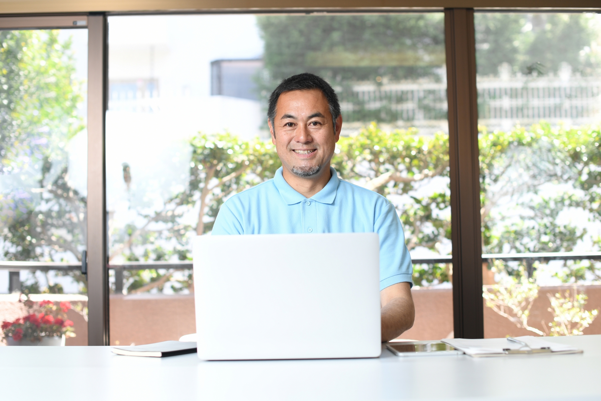 PCで事務作業をする笑顔のアジア人男性