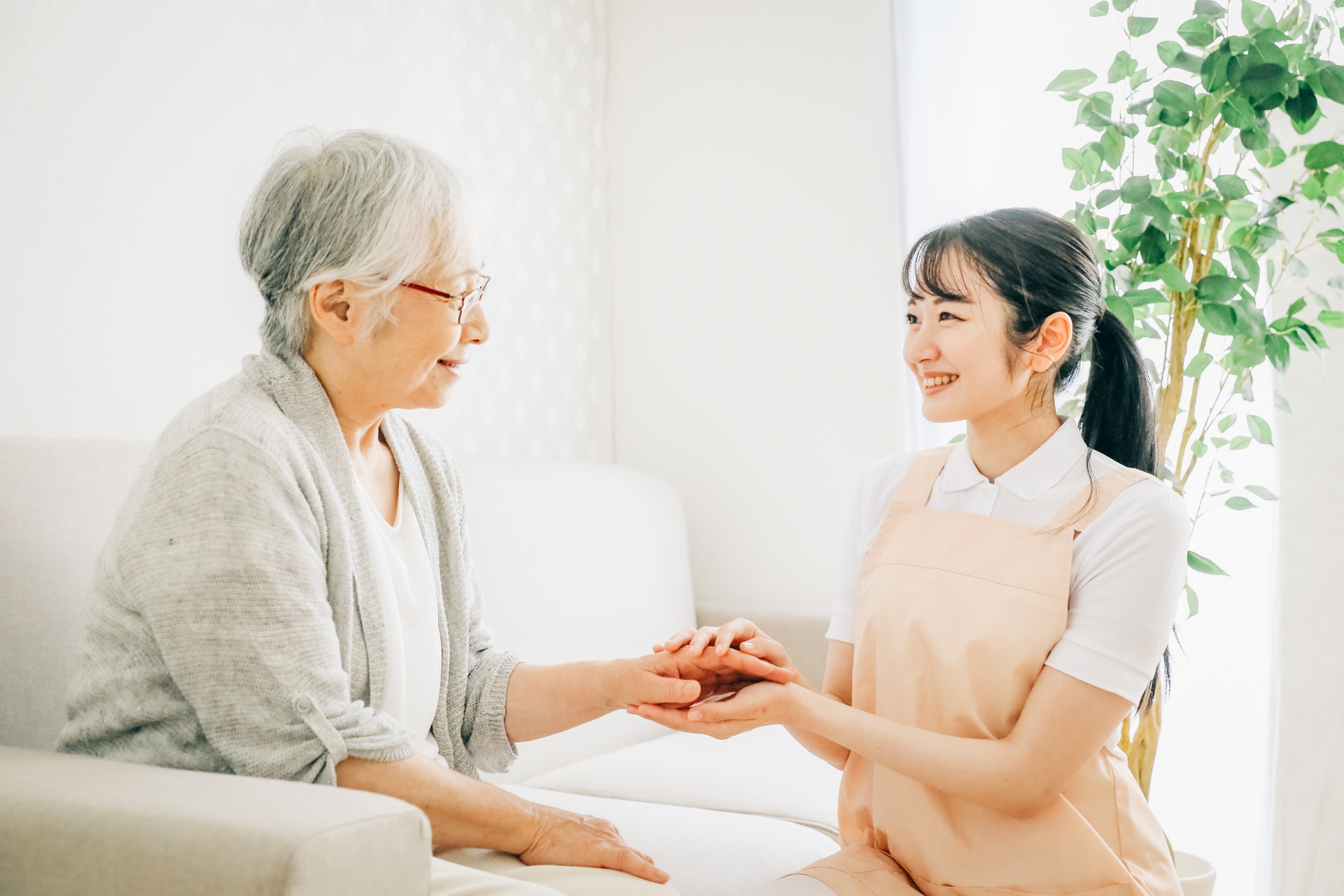 訪問介護する女性と高齢者（笑顔）