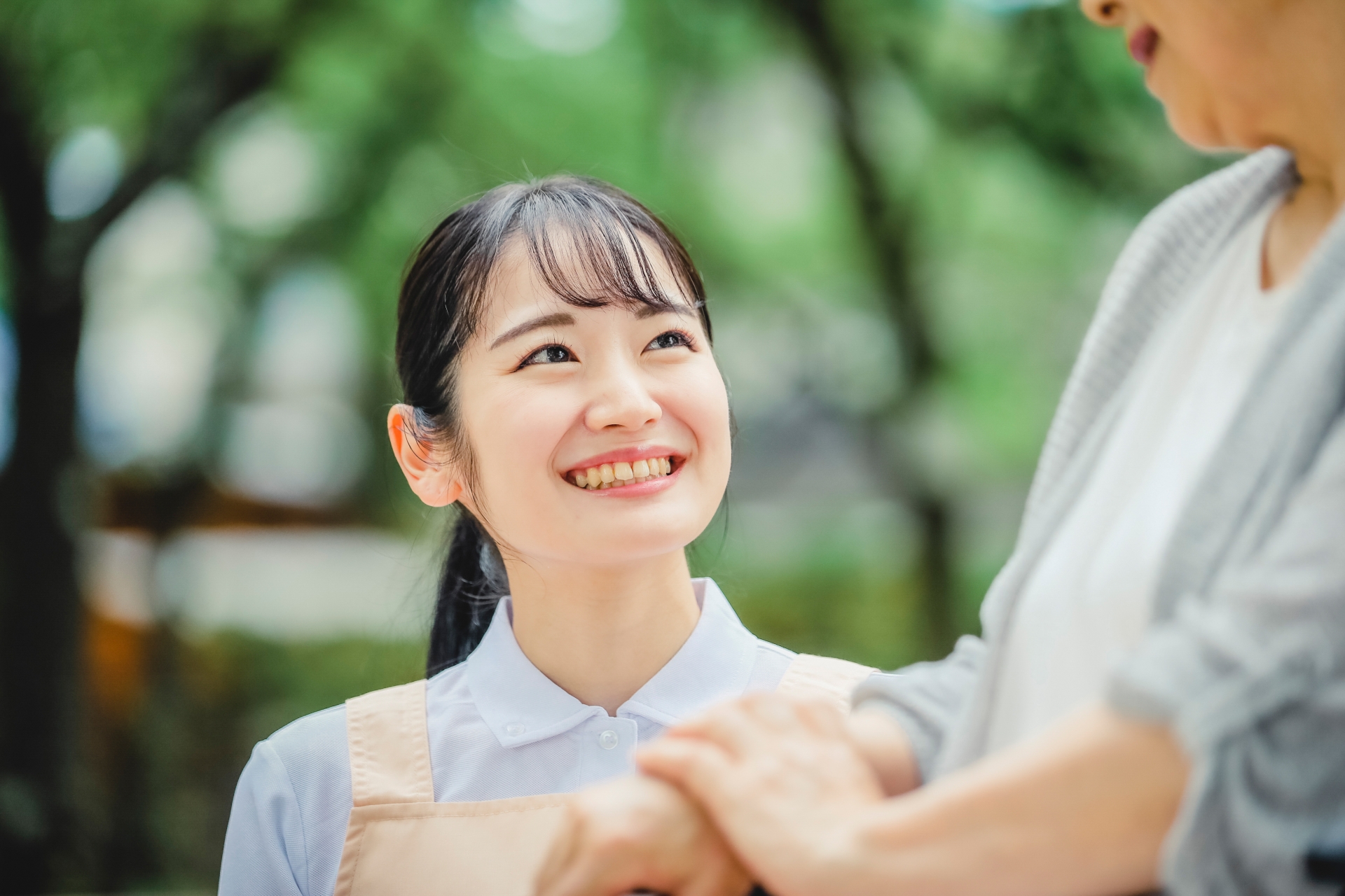 車椅子に乗った高齢者女性と女性スタッフ