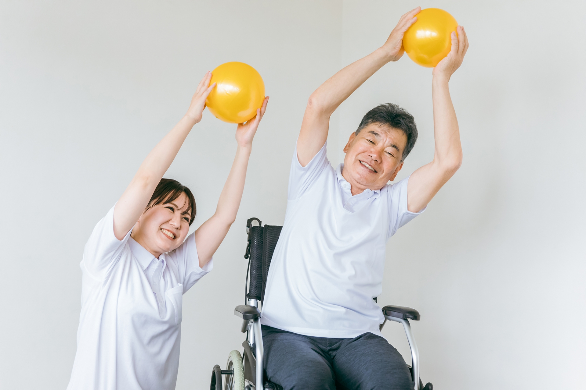 体操するシニアとトレーナー