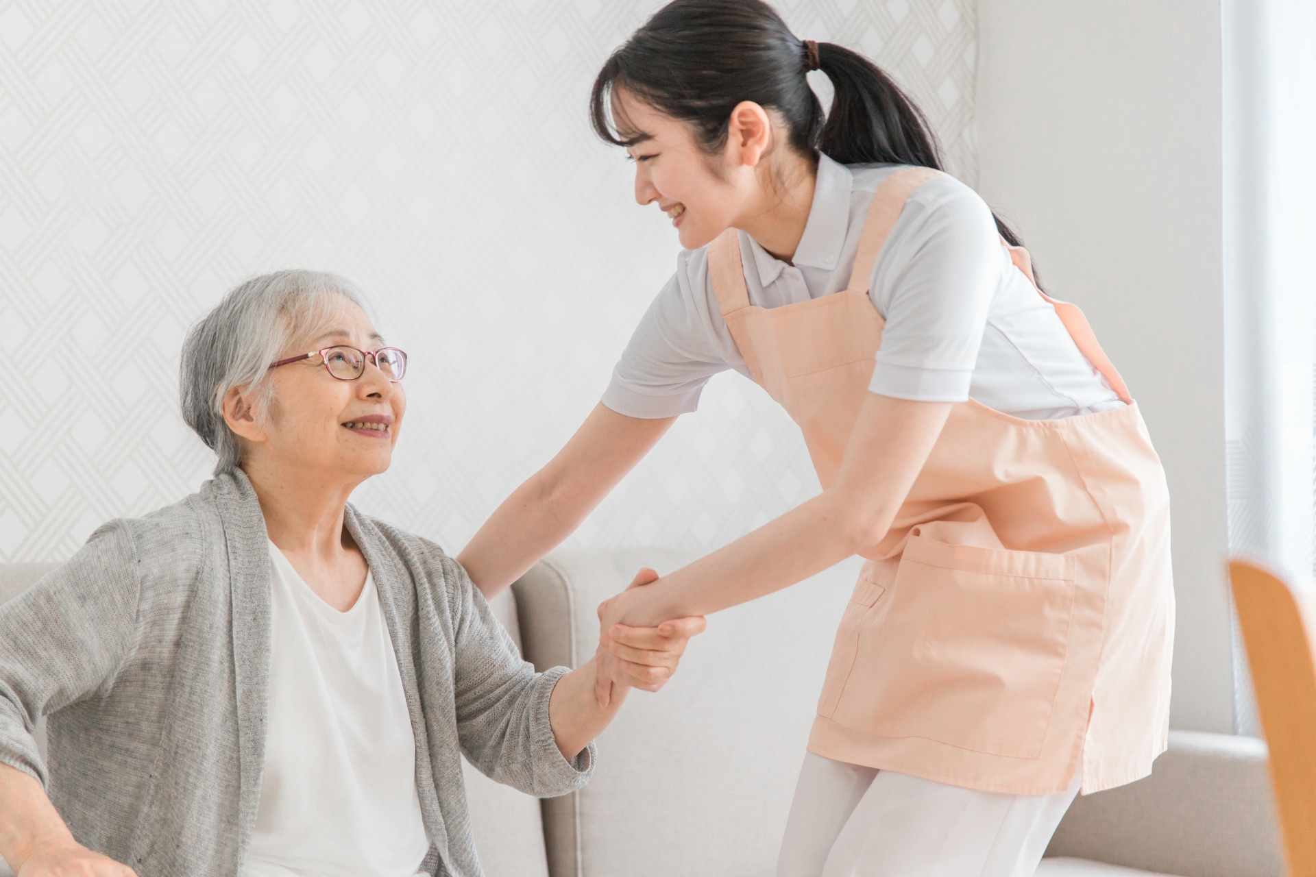 訪問介護する女性と高齢者（笑顔）